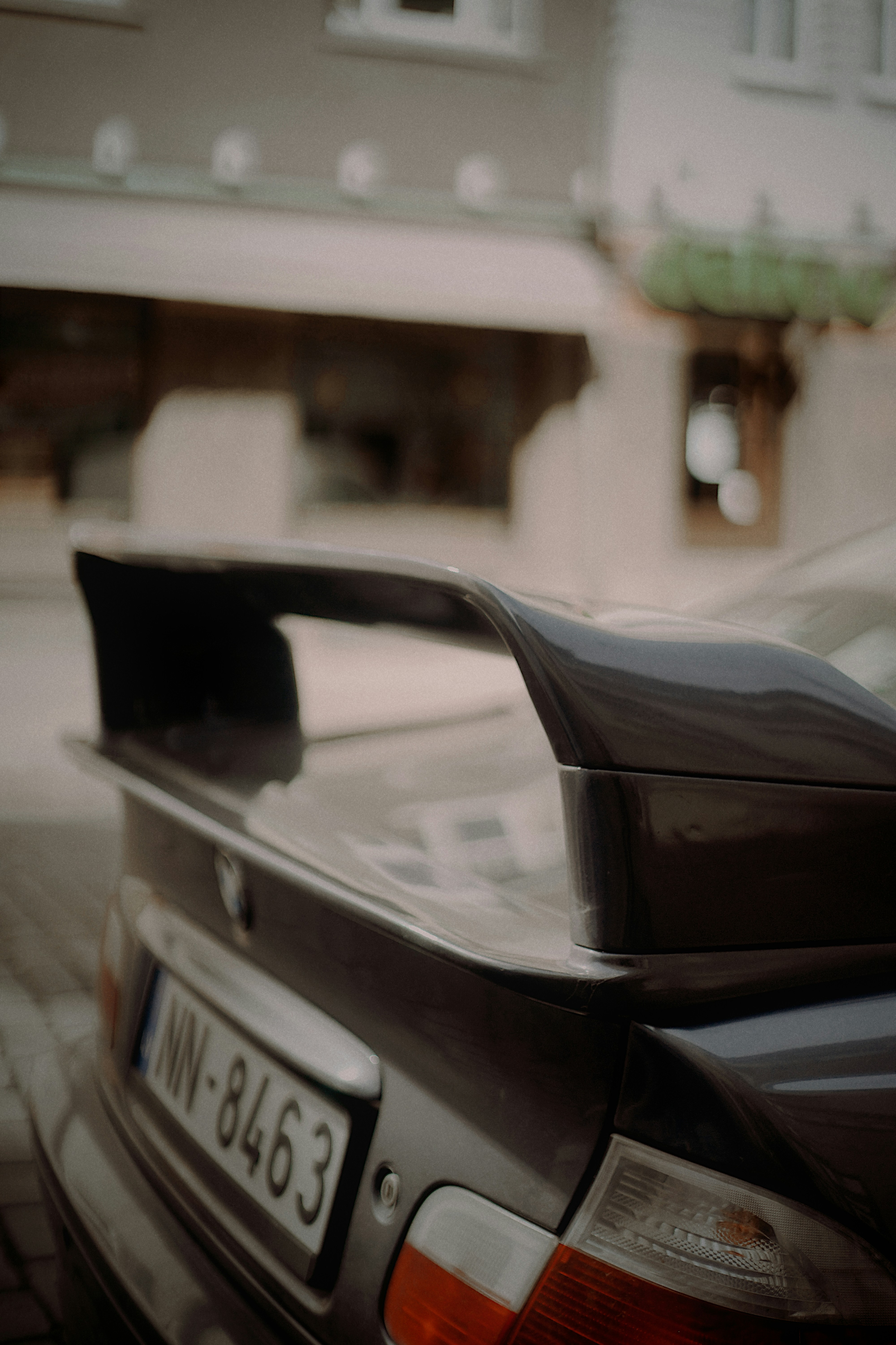 Carro escuro com grande spoiler e placa