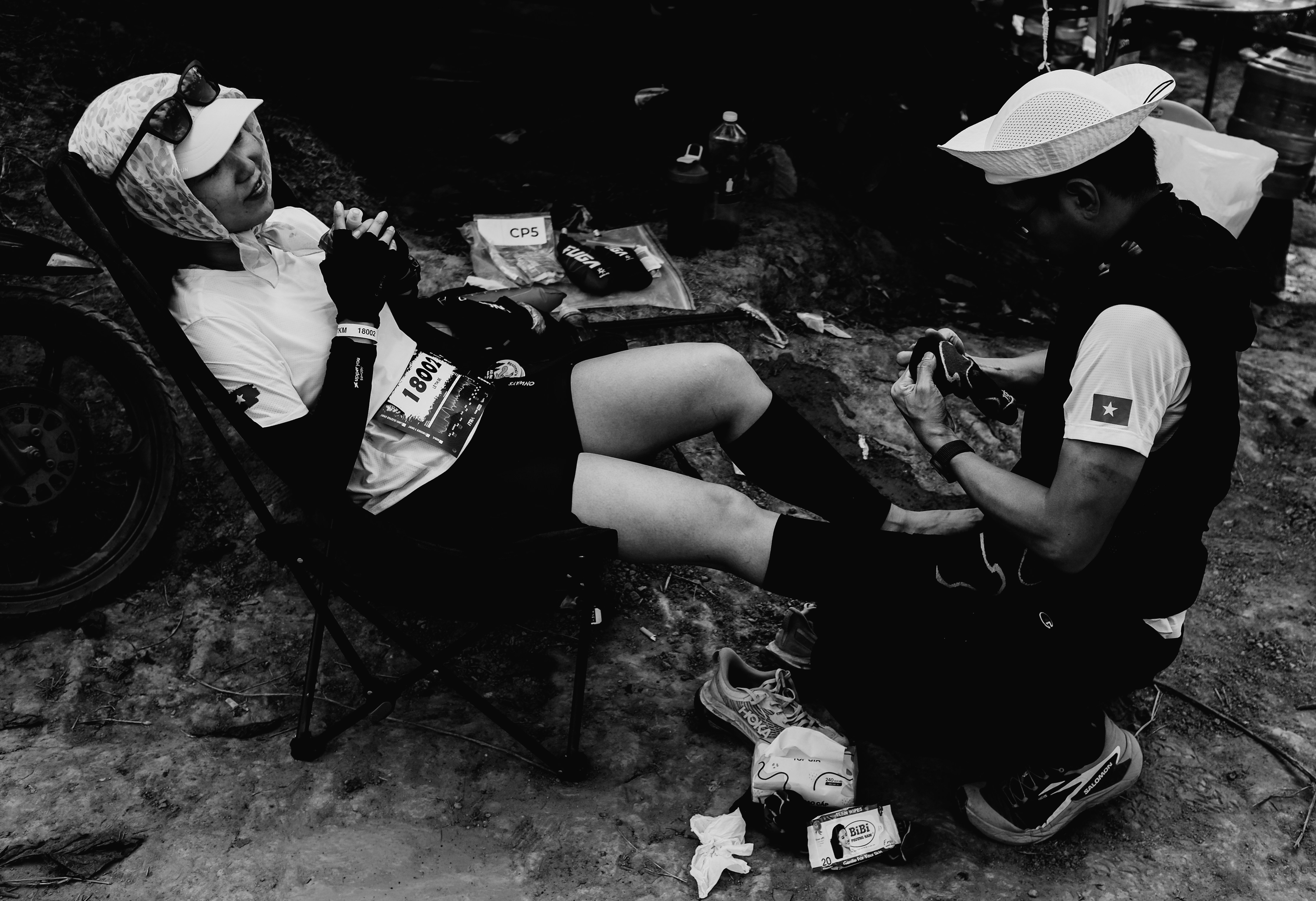 Atlet beristirahat saat menerima bantuan selama perlombaan.