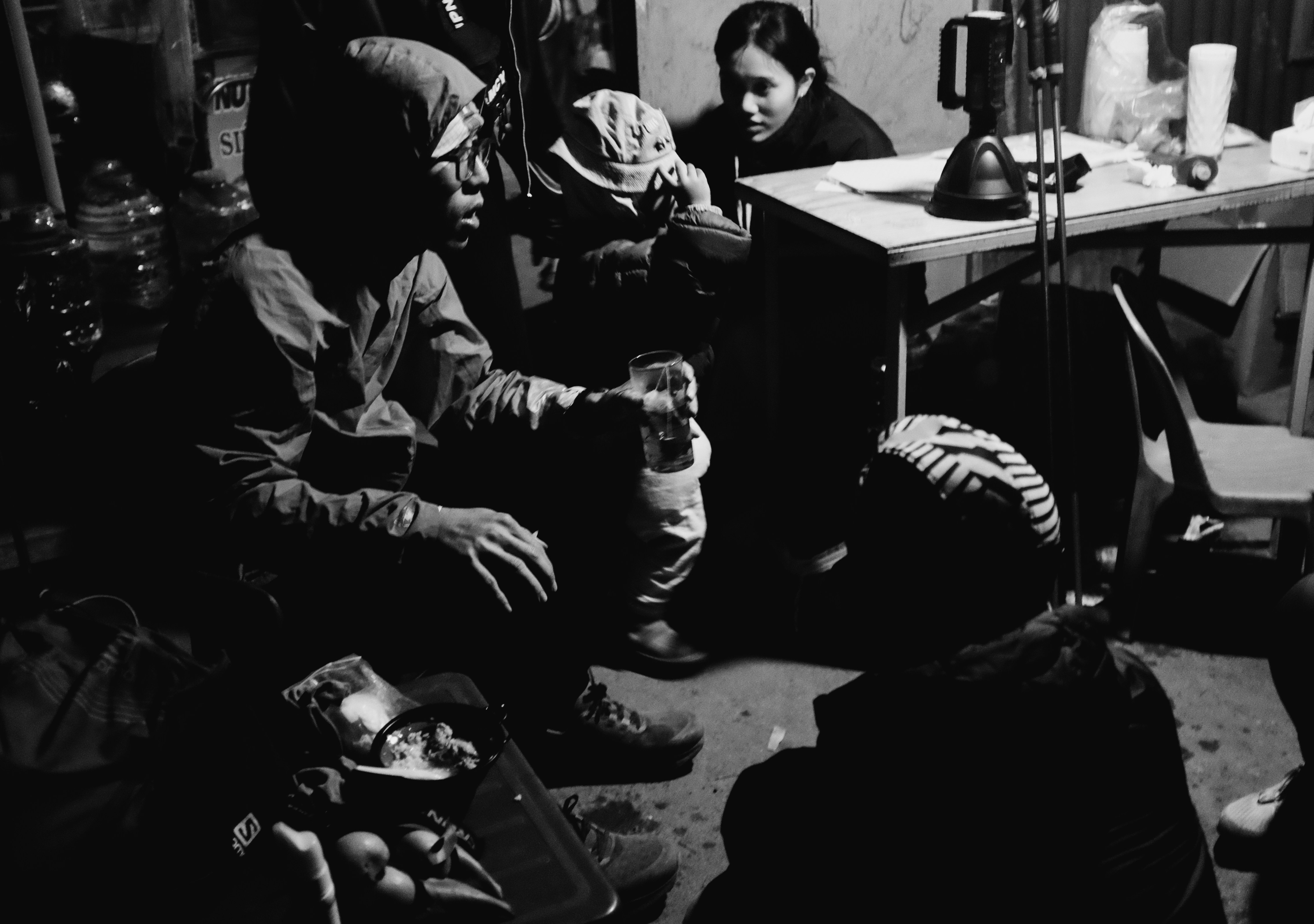 La gente si radunò in una stanza debolmente illuminata