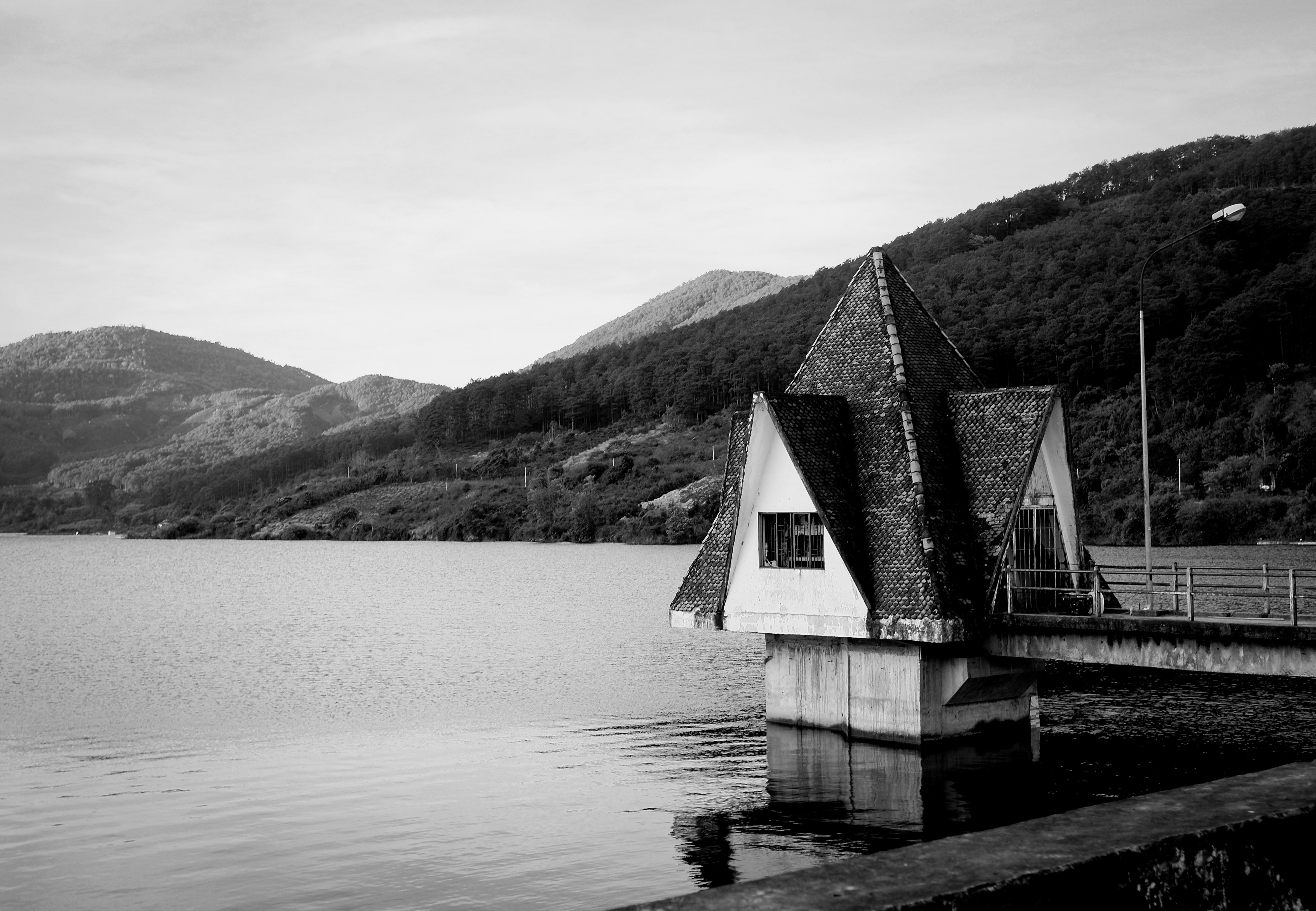 Edificio sulla riva di un lago con montagne sullo sfondo