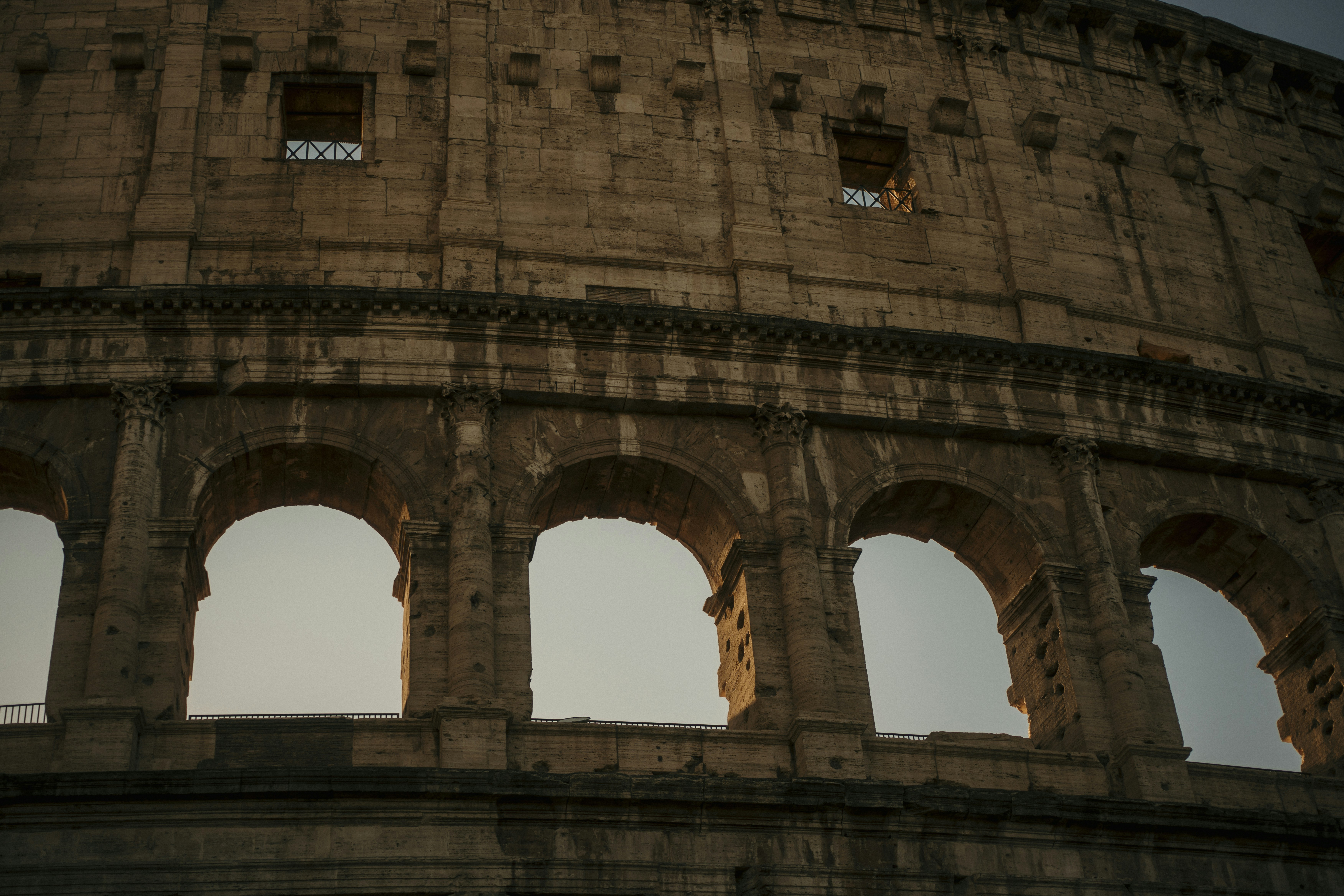 Ancient roman colosseum arches at sunset