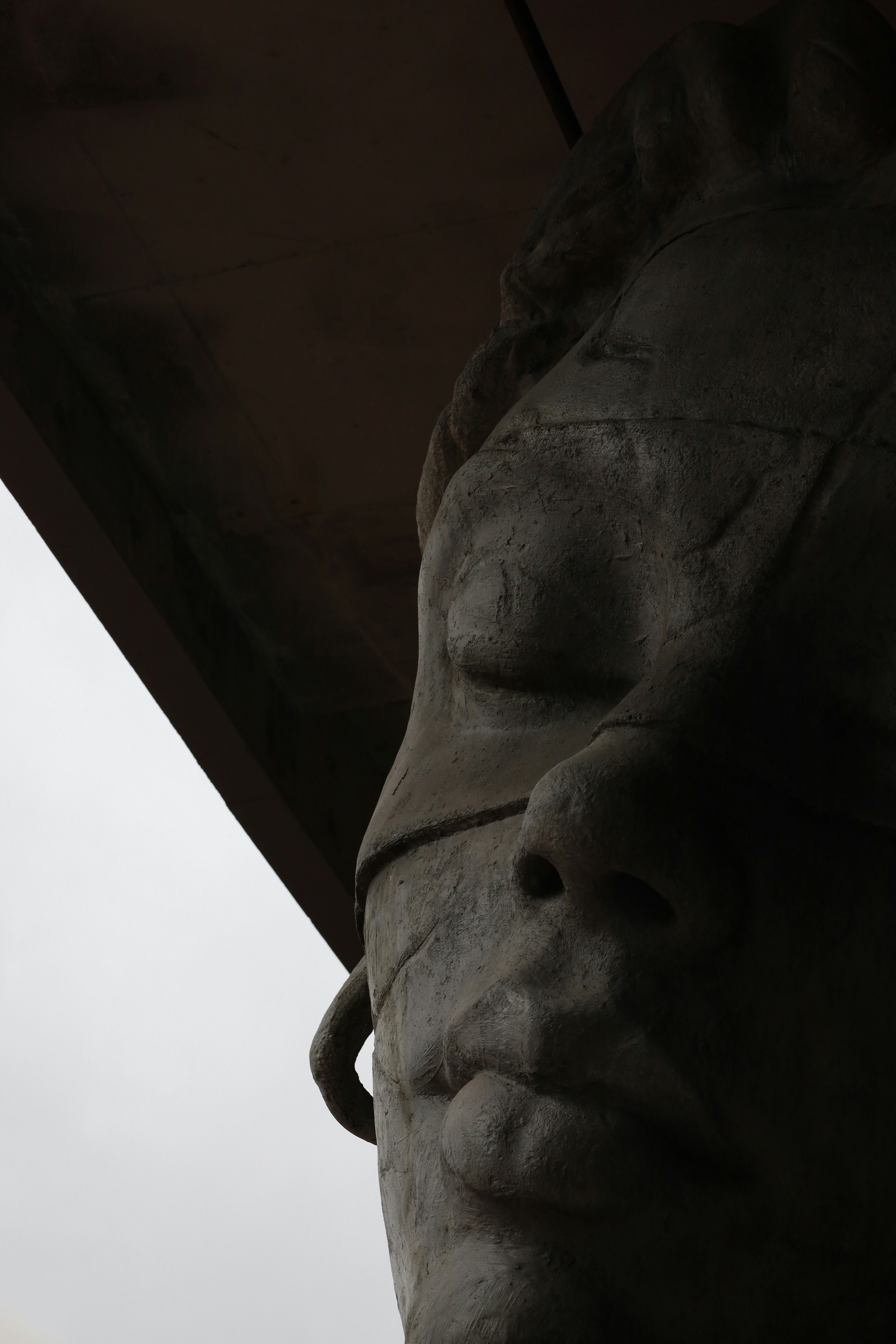 Statue de pierre avec les yeux couverts d’un bandeau.