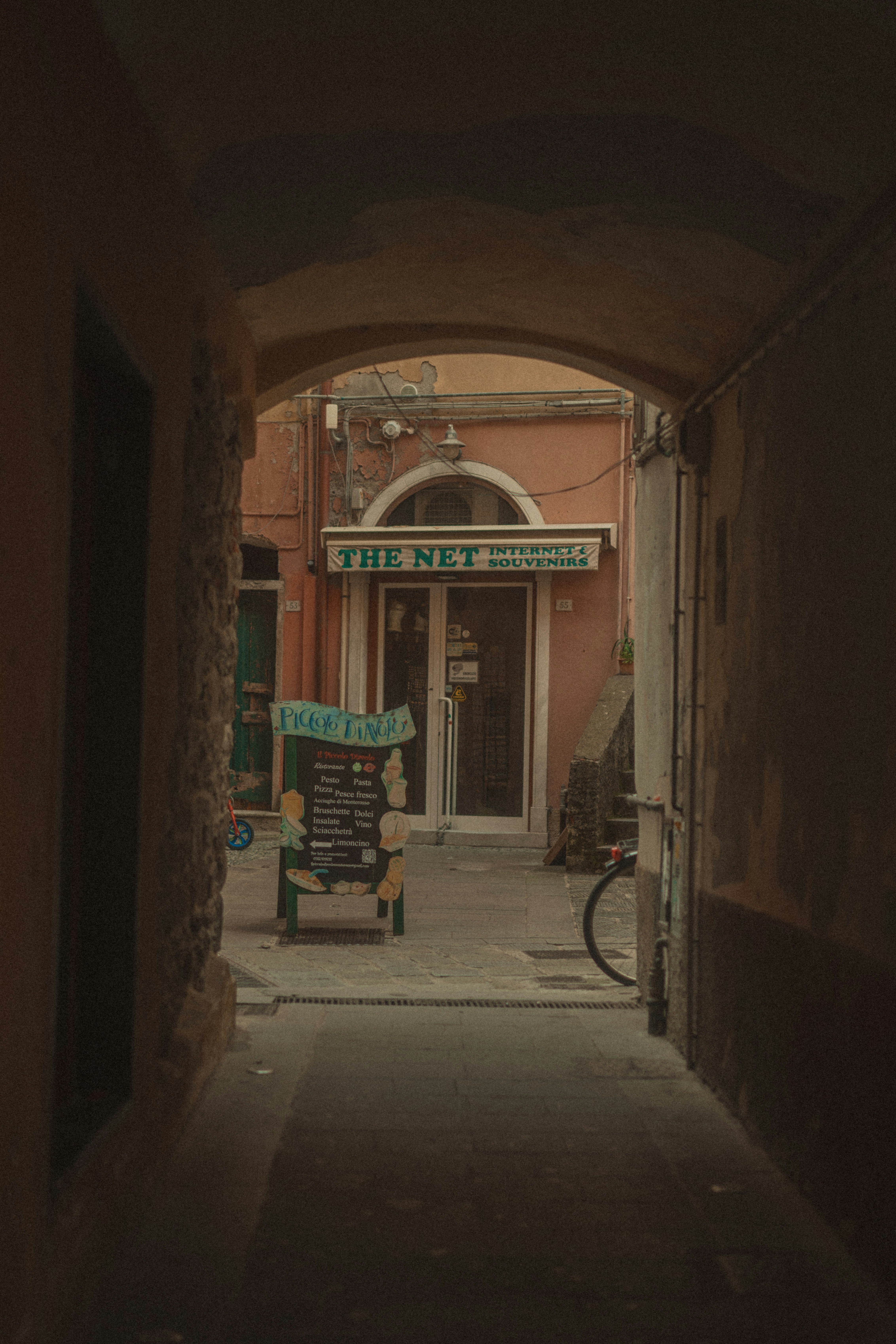 Arched alleyway leading to a shop entrance.