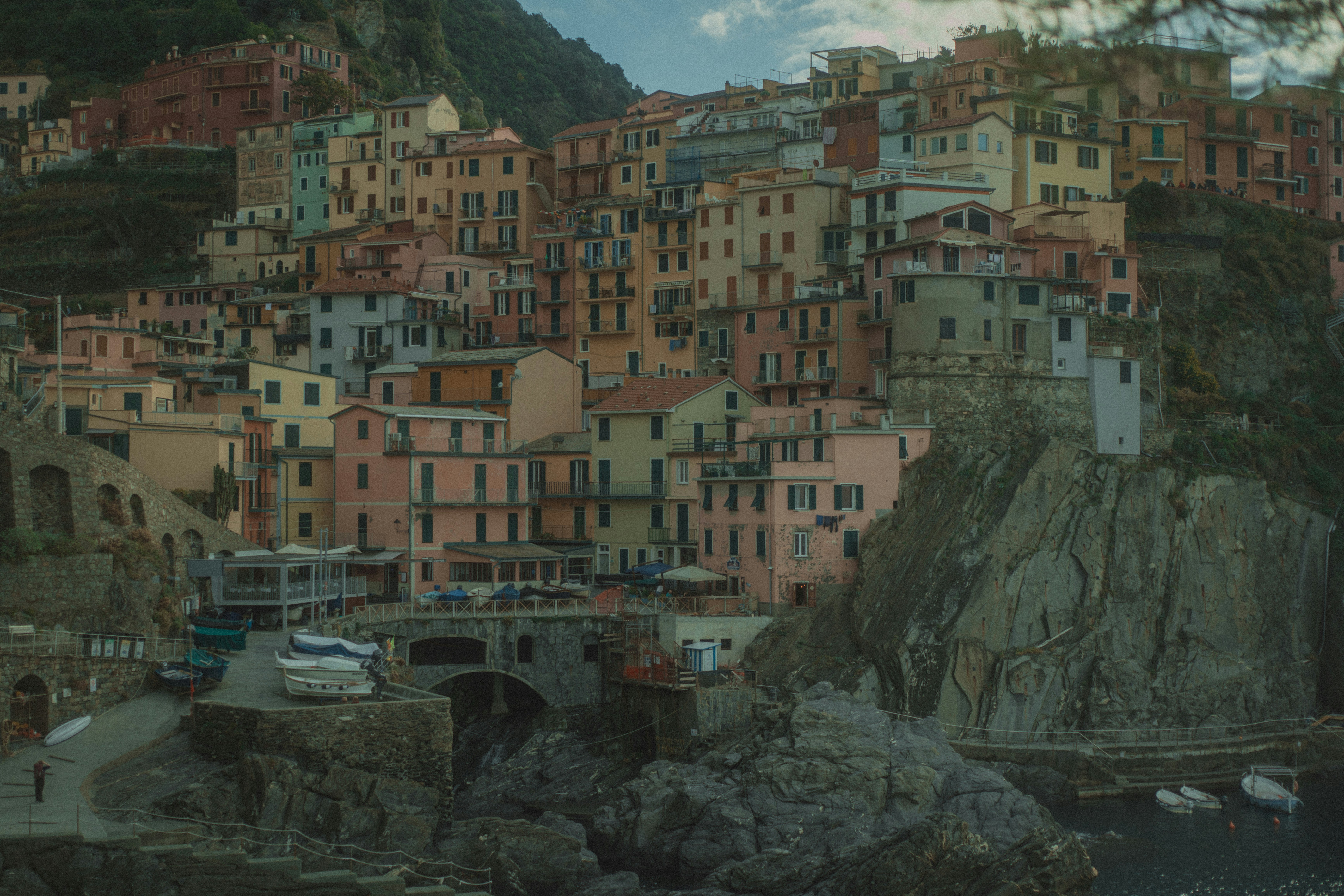 Colorful buildings cling to a steep italian coastal cliff.