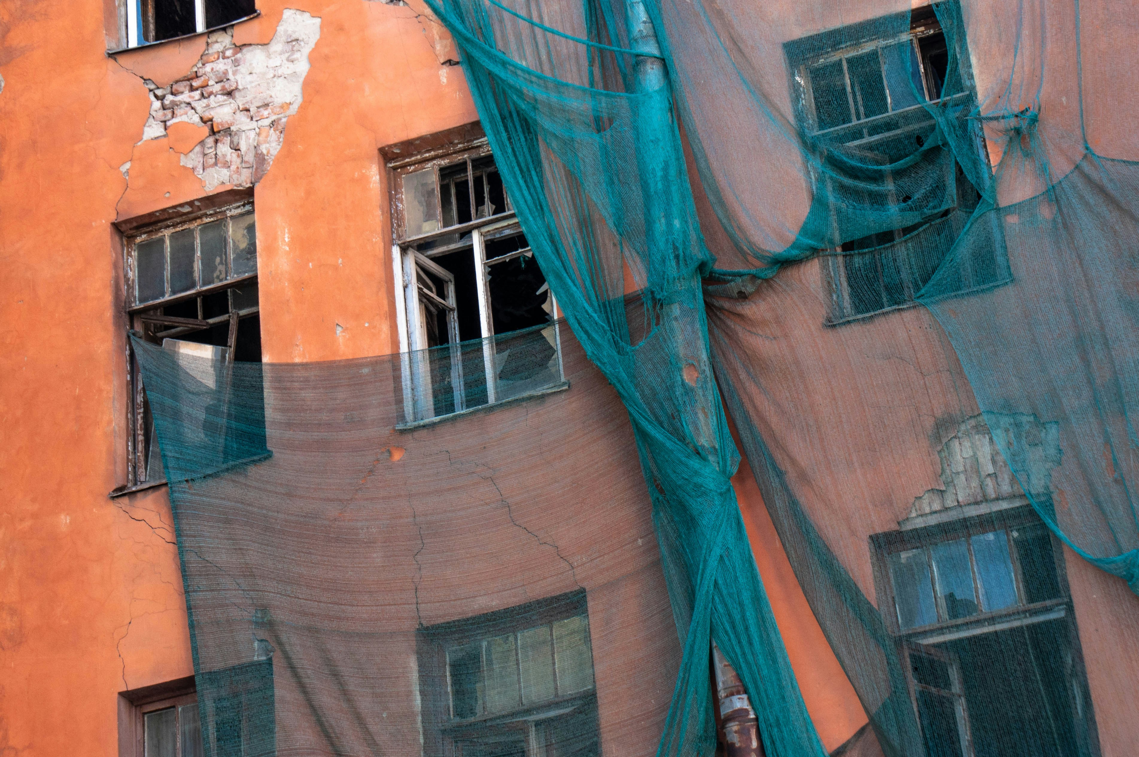 Old building facade covered with green netting