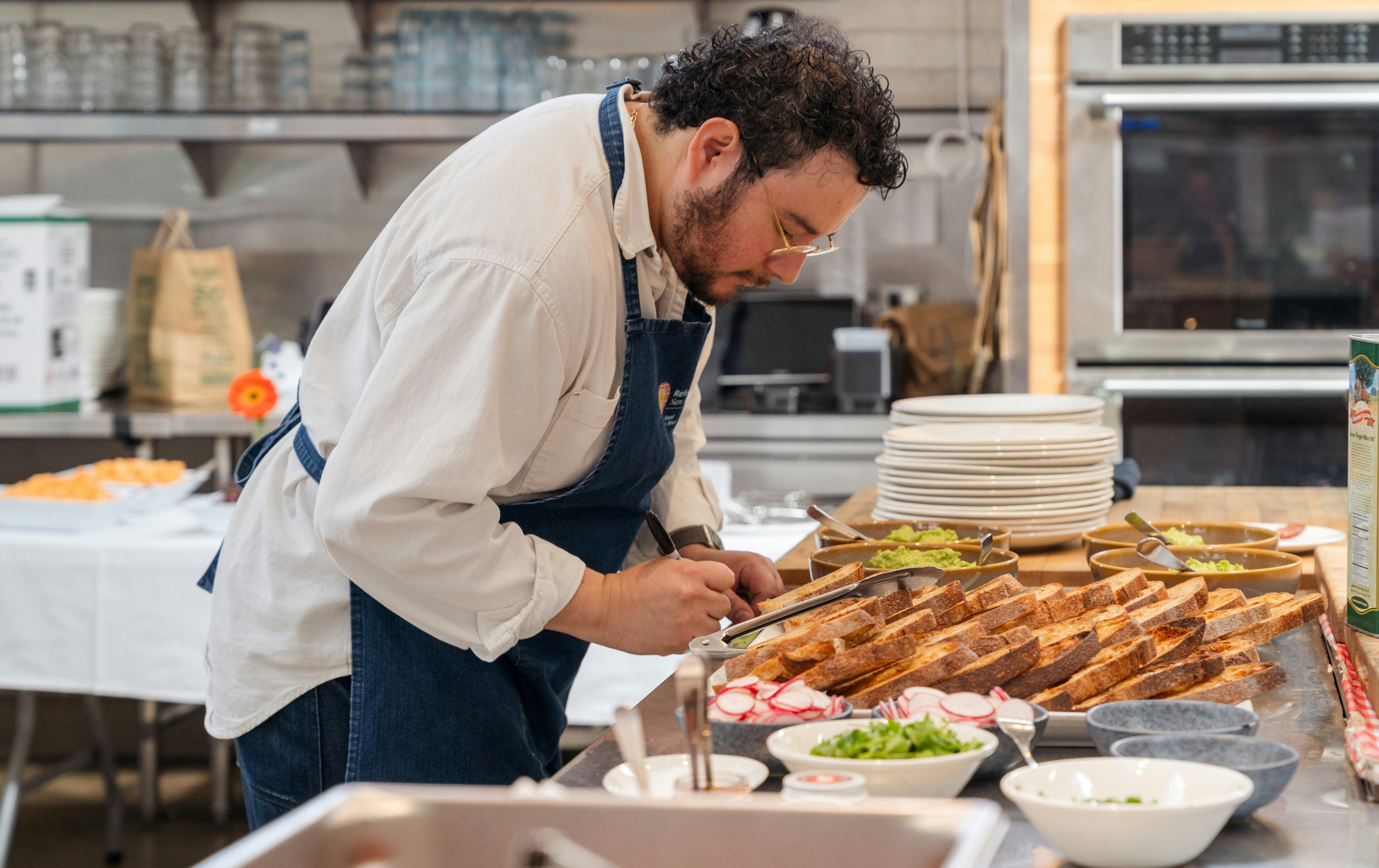 A chef prepares food in a busy kitchen.