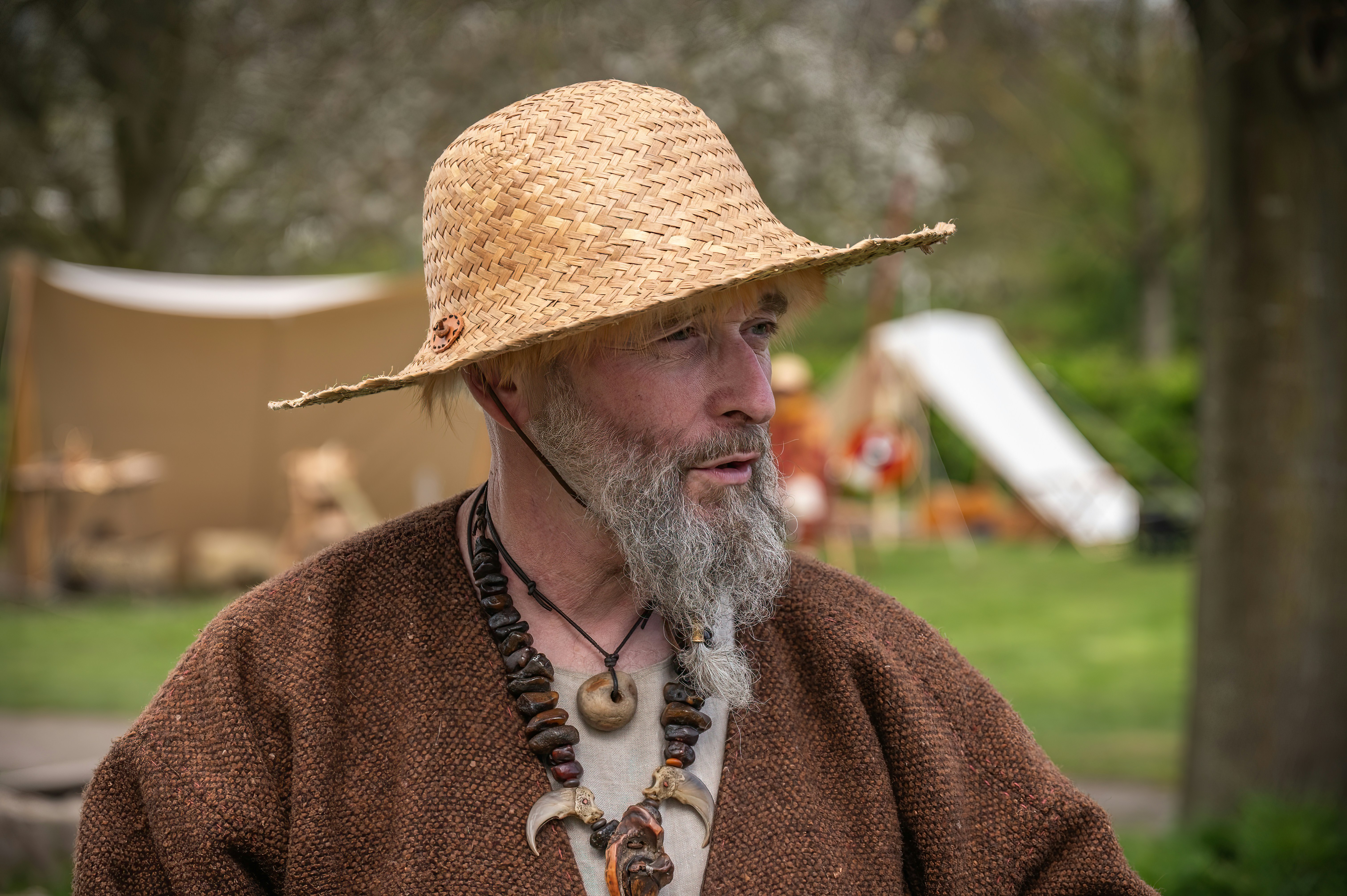 Man with straw hat and beard wears tribal necklace