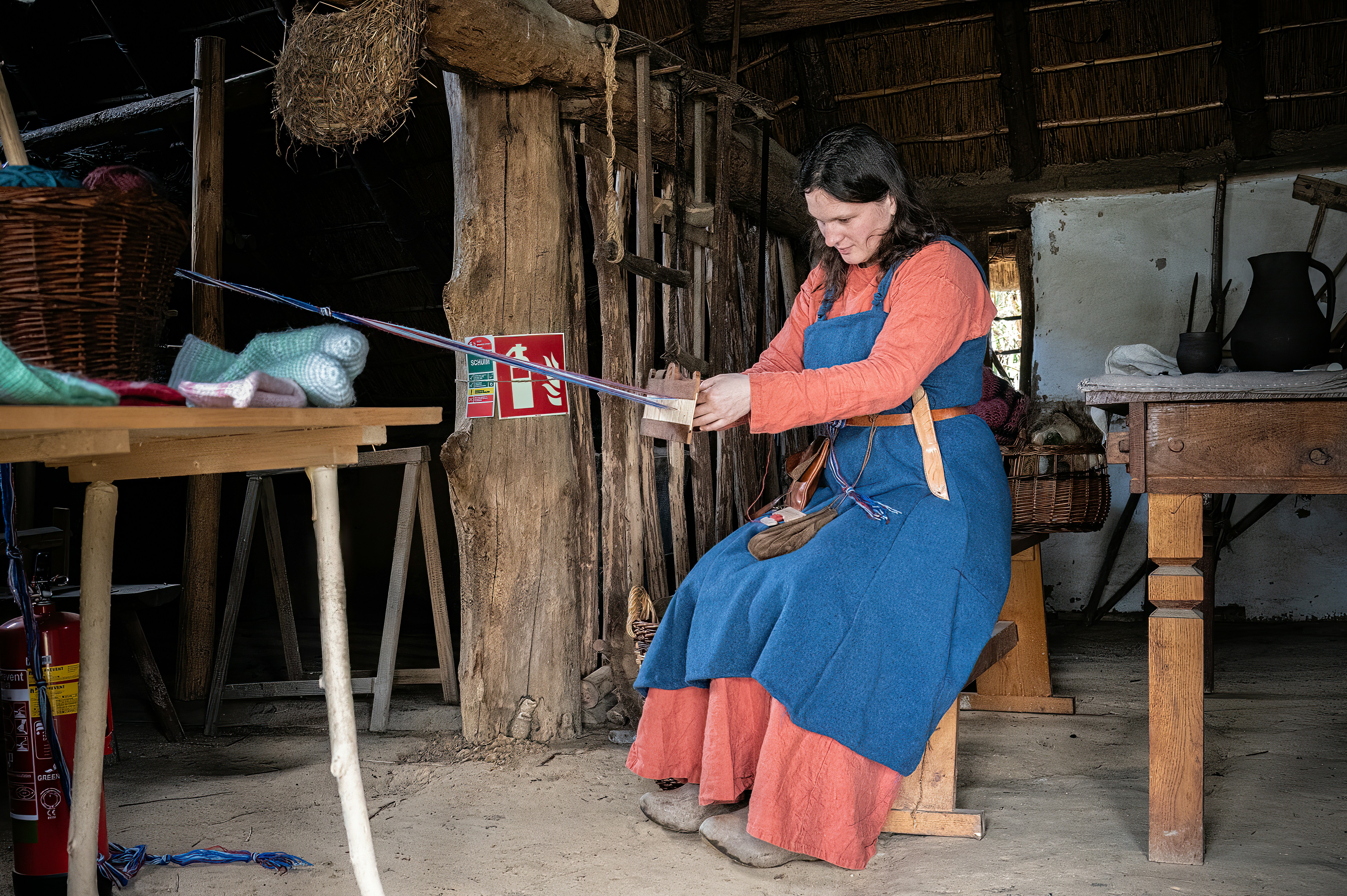 Woman in historical clothing working with a tool