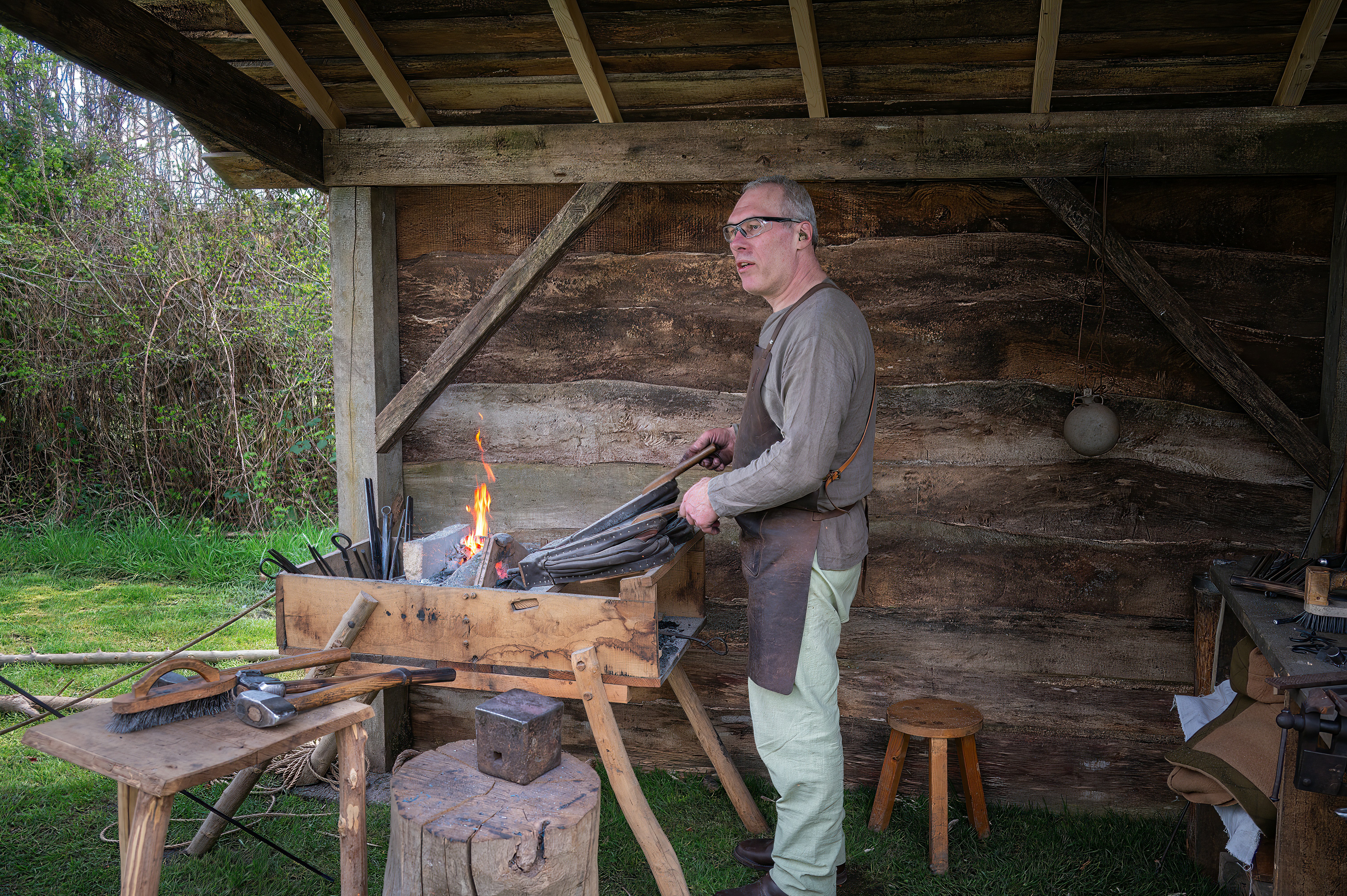 Blacksmith working at a forge with flames