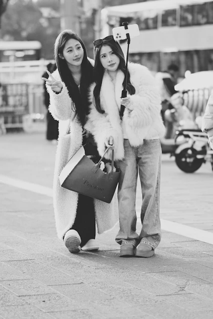Two women taking a selfie with a selfie stick.