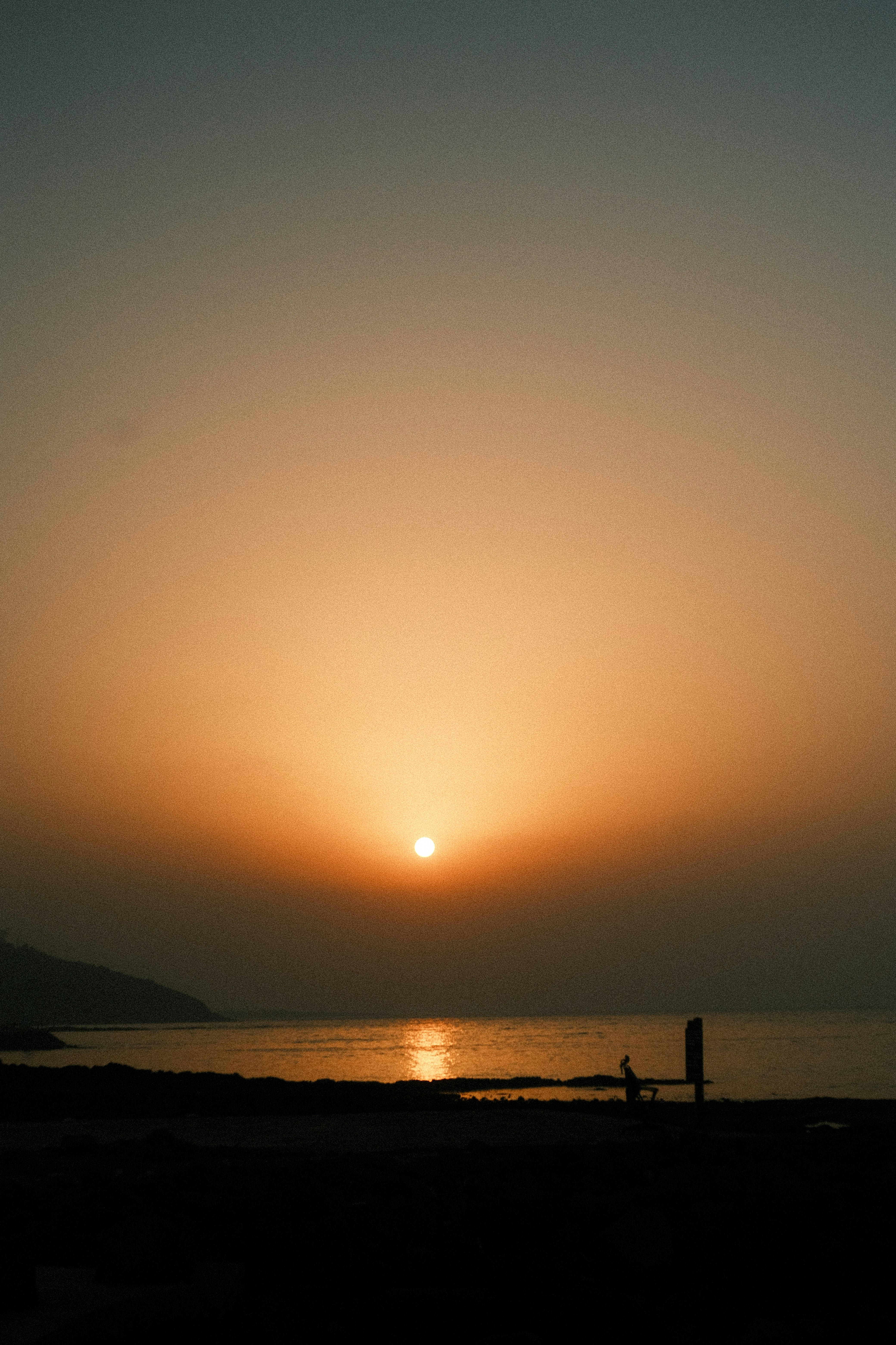 Coucher de soleil sur un océan calme avec un banc en silhouette