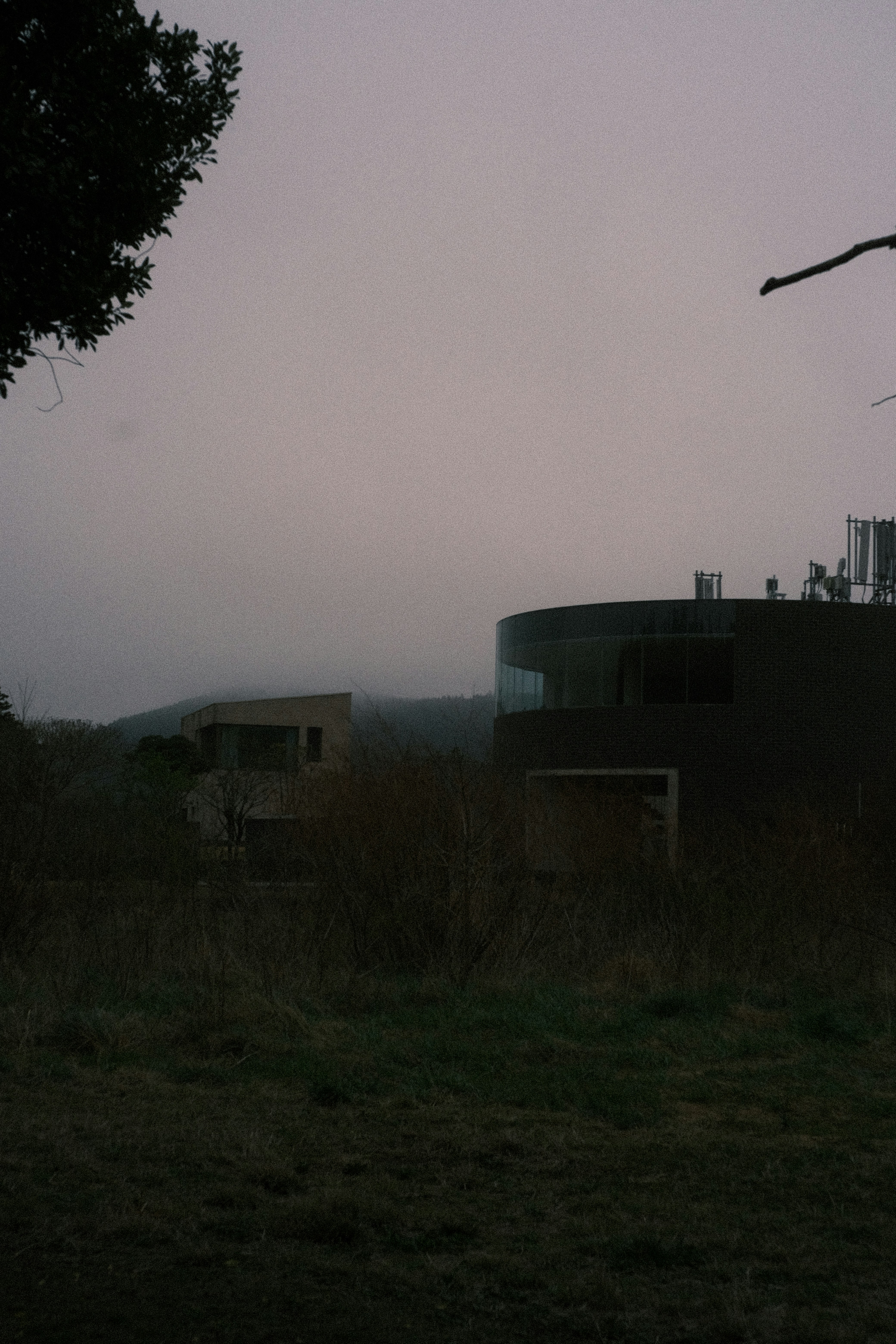 Deux bâtiments modernes dans un paysage brumeux