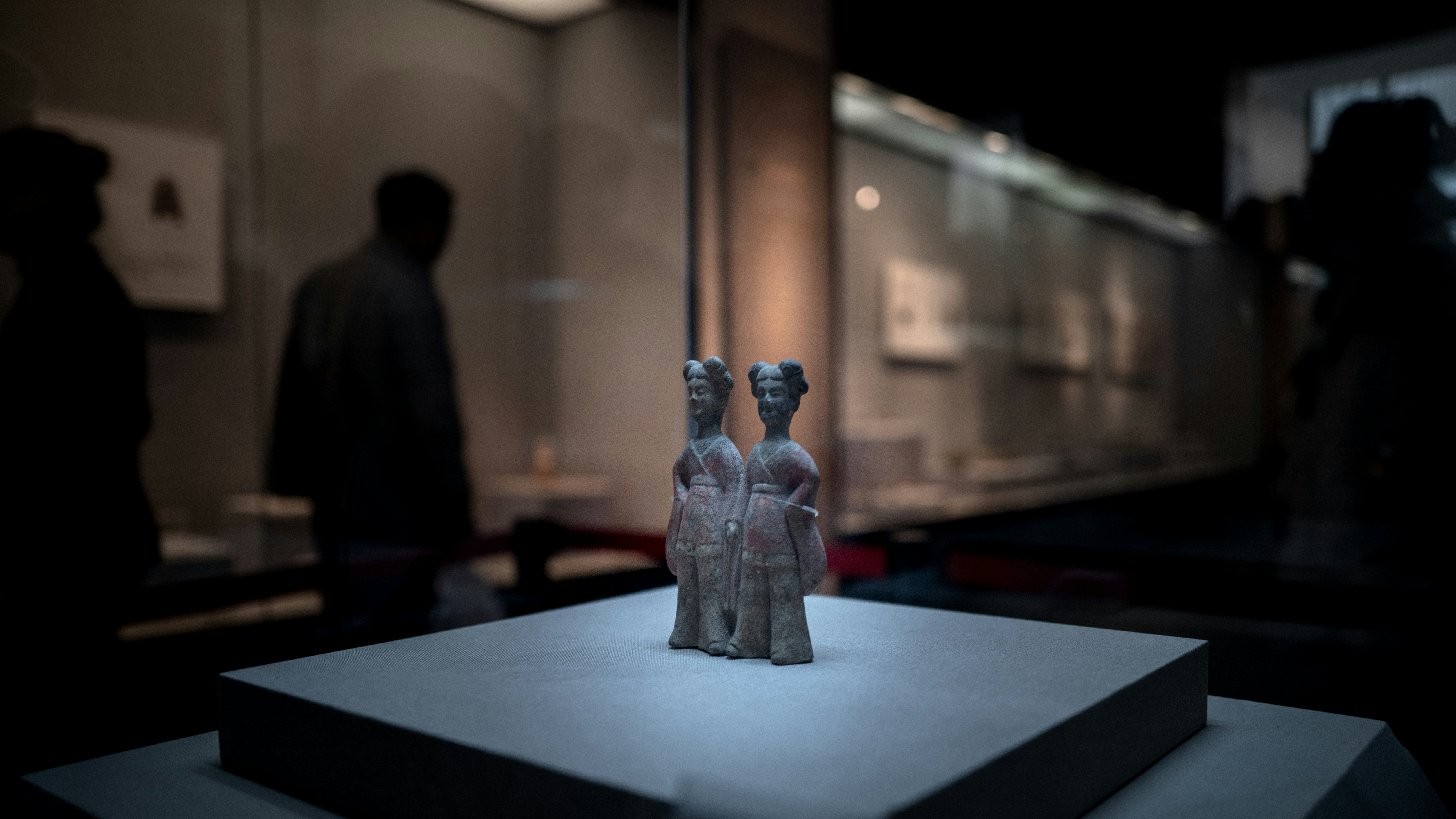 Deux figurines anciennes exposées dans une exposition muséale
