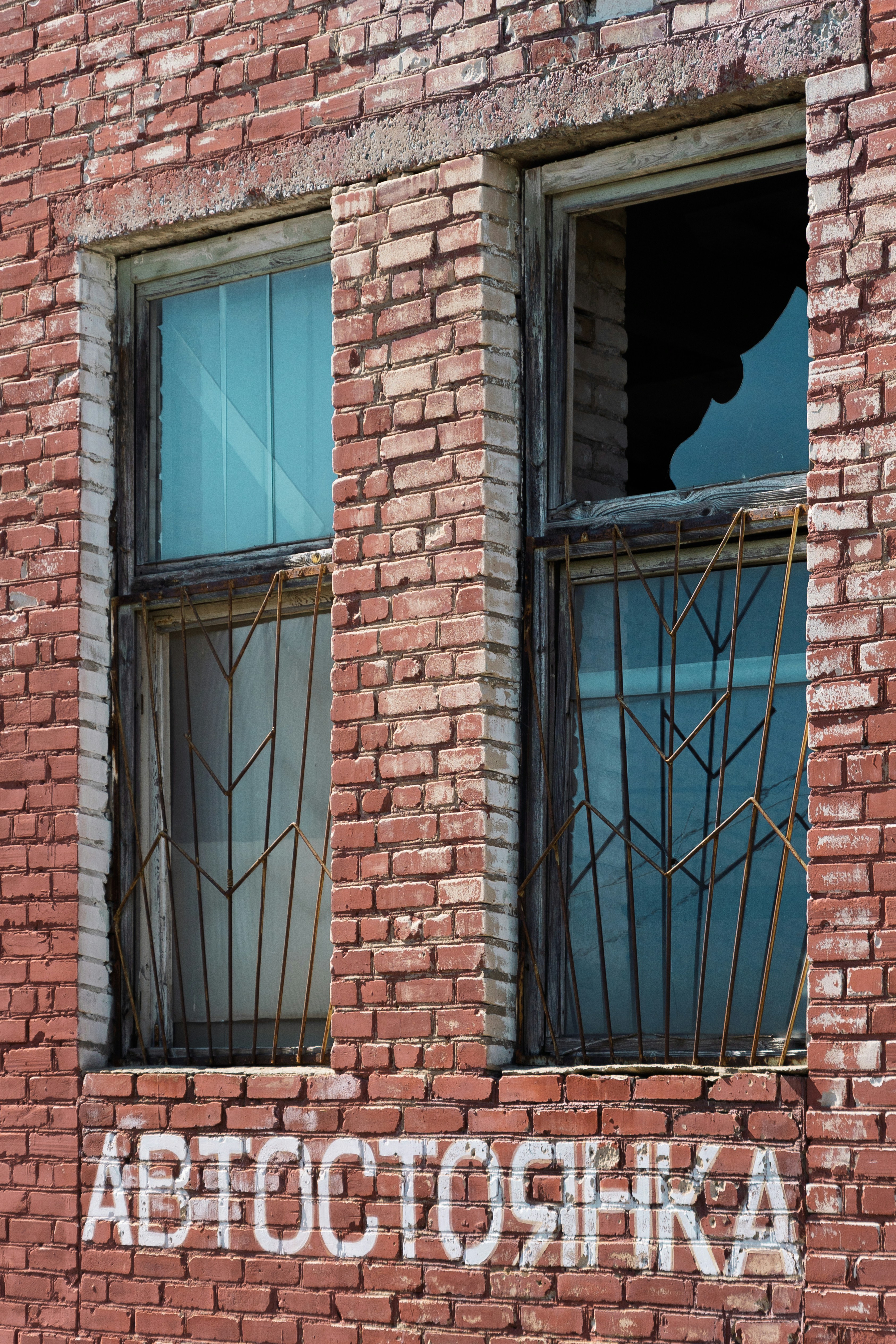 Broken window on a brick building with russian text