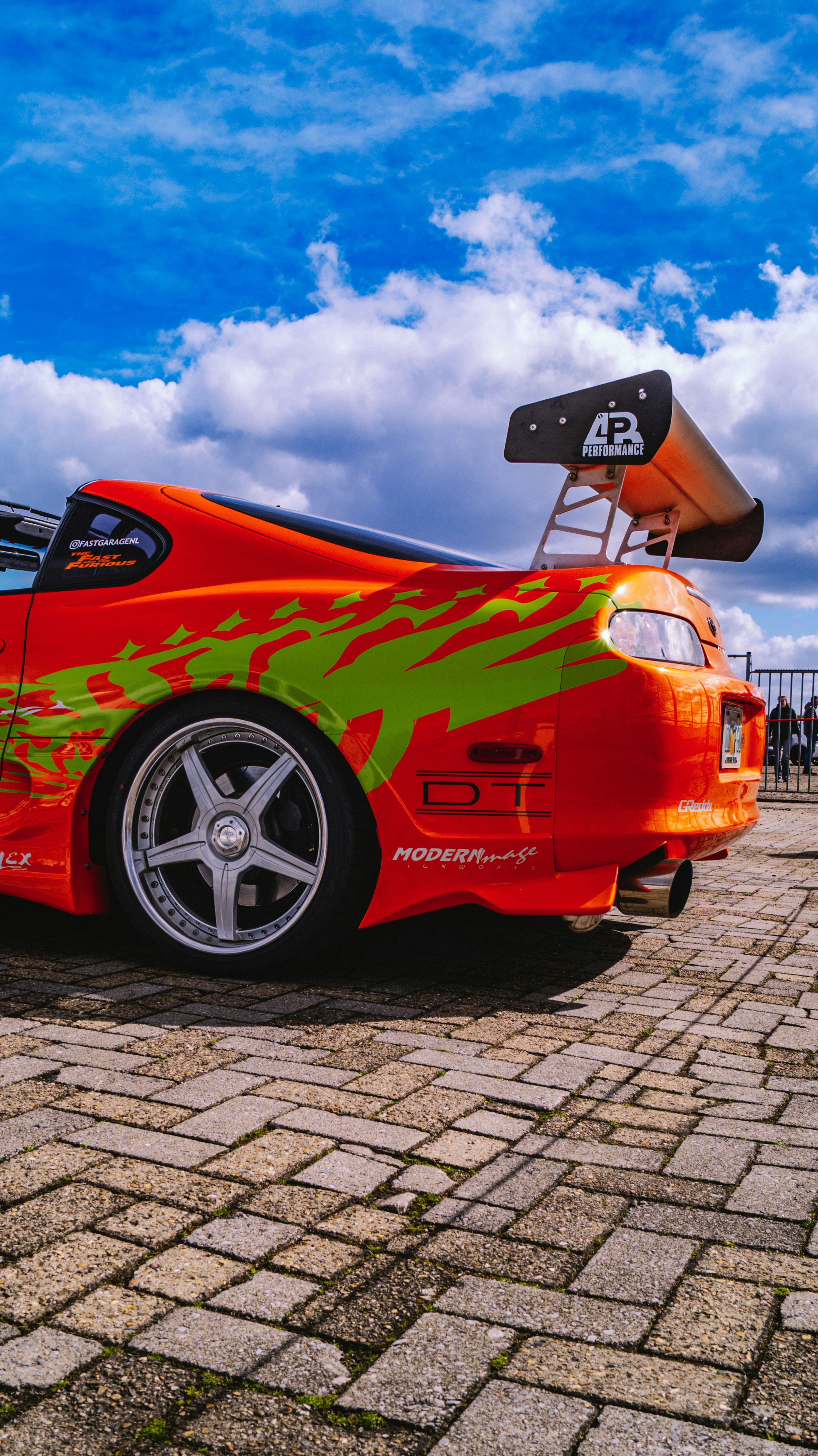 Orange sports car with green graphics and large spoiler.