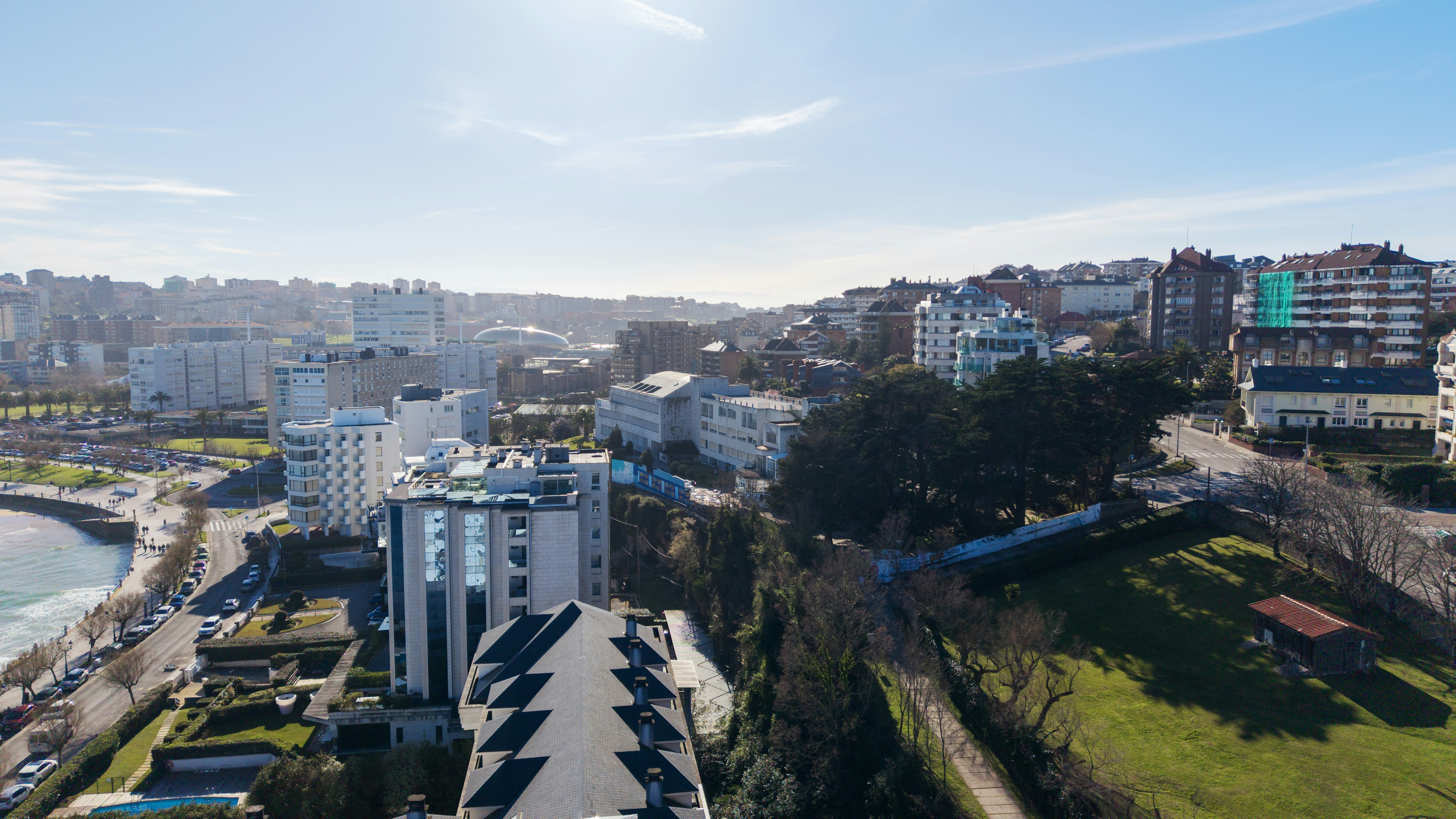 Coastal city skyline with modern buildings and green spaces.