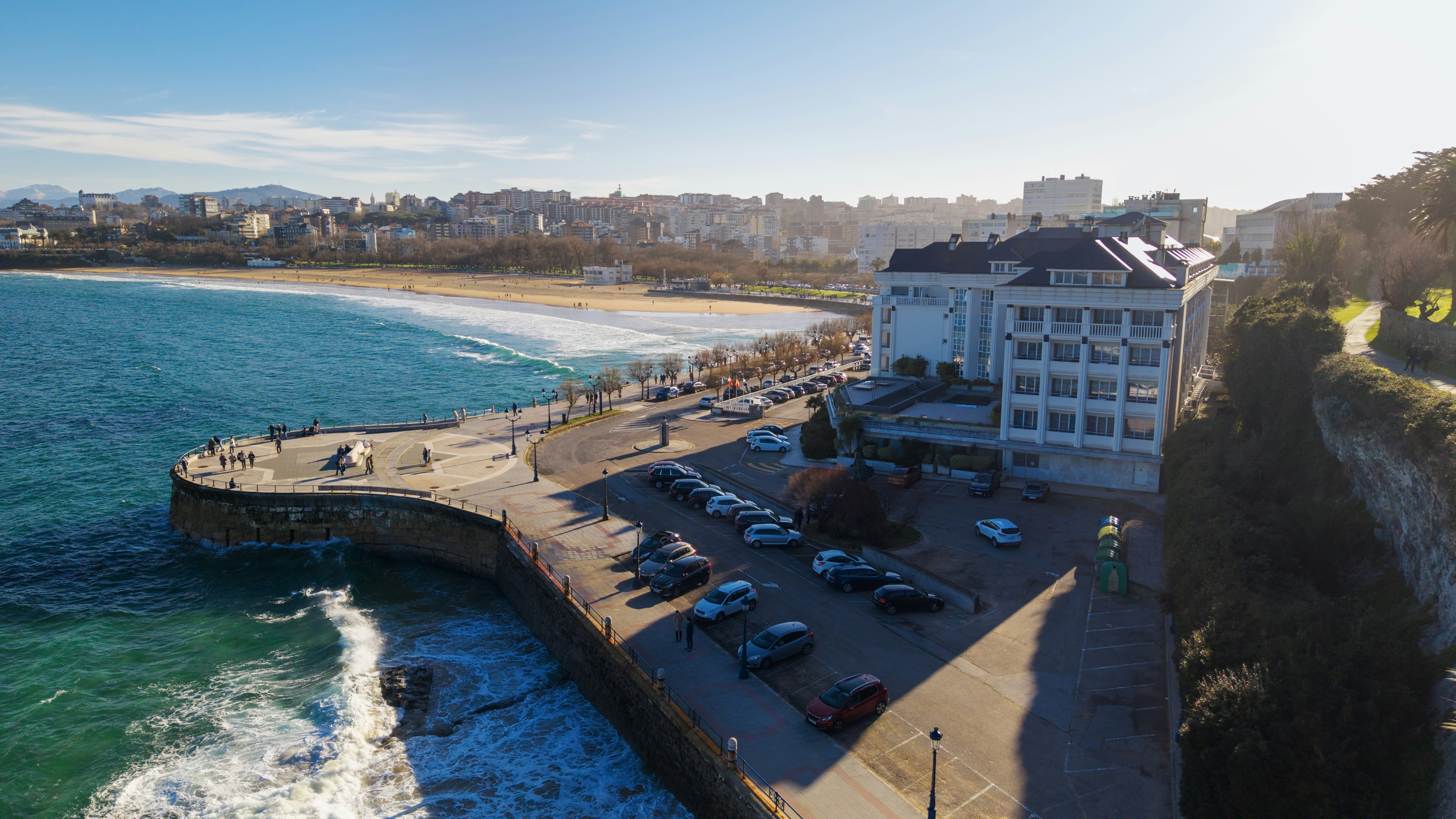 Coastal town with a pier, beach, and buildings.