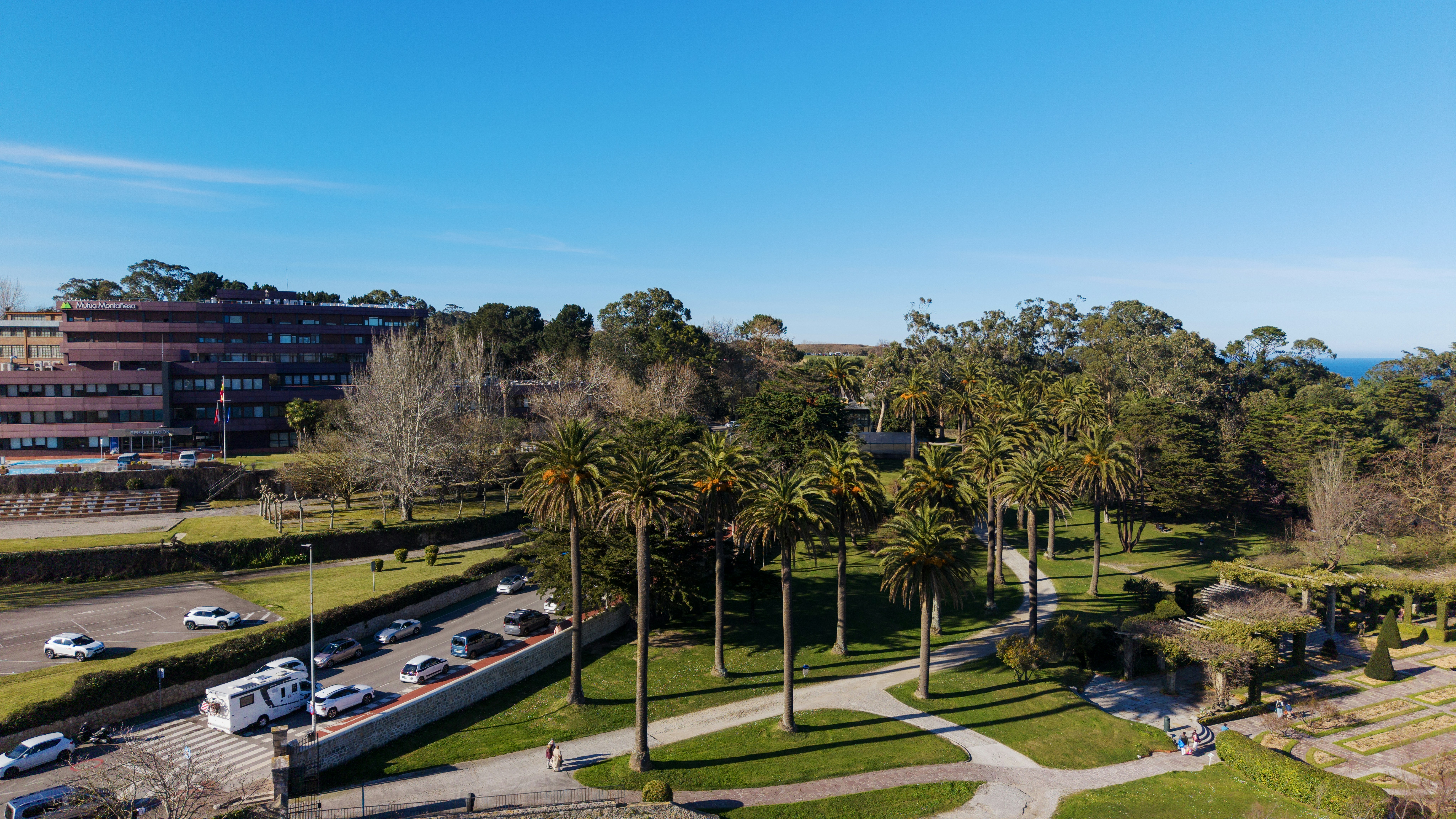 Buildings and palm trees in a park with ocean view