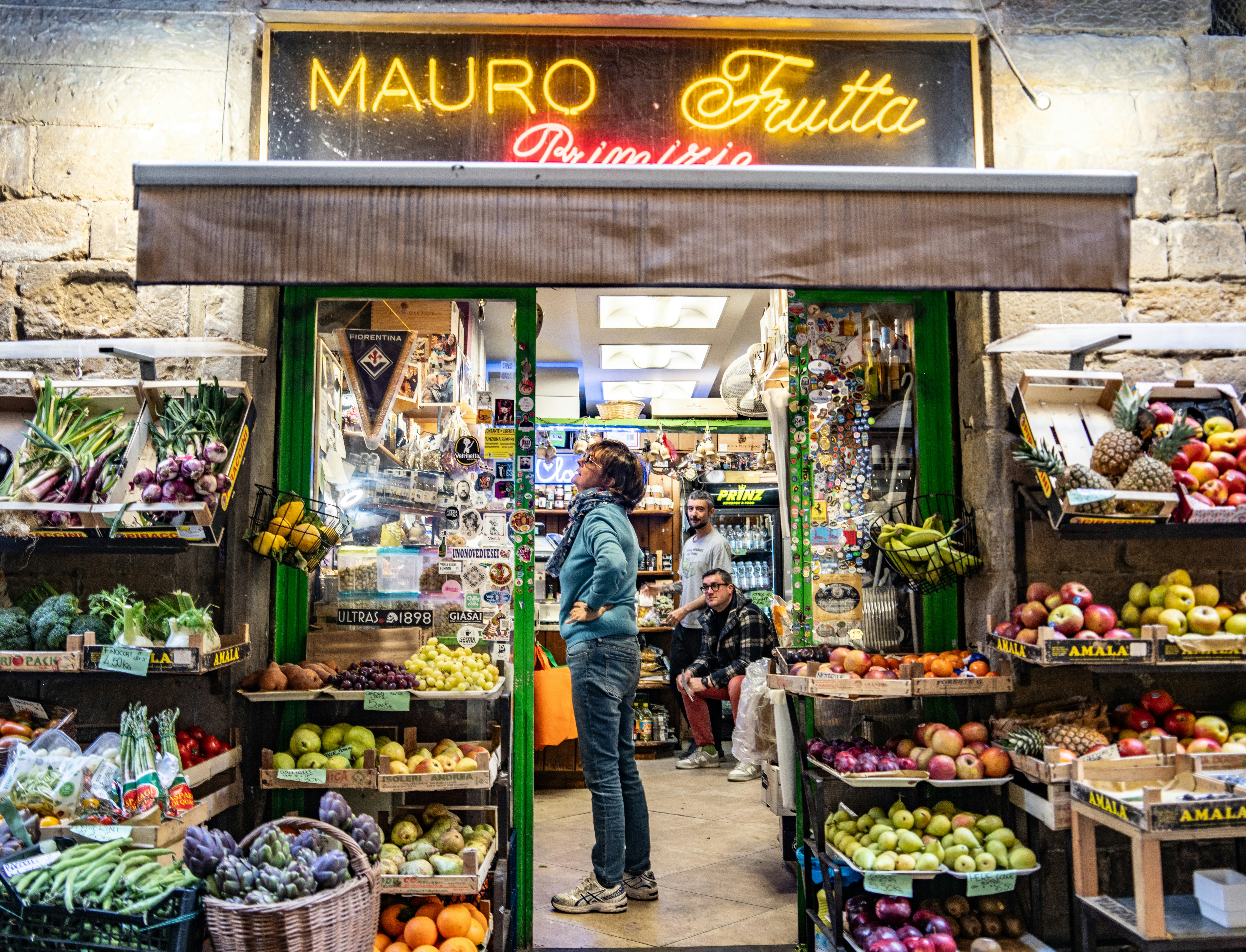 a fruit stand with a neon sign that says mauro