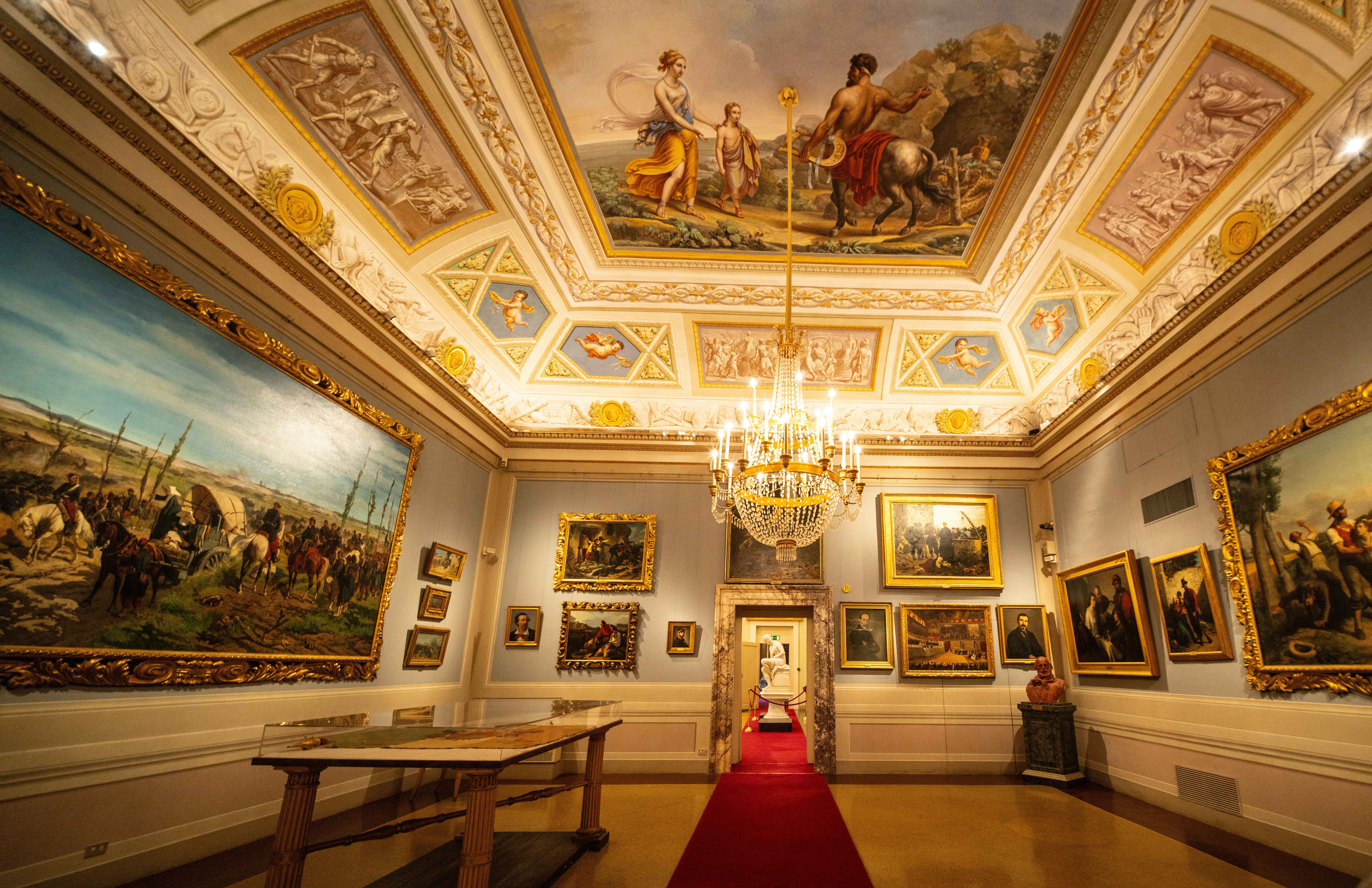 Elegant hall with paintings and a red carpet