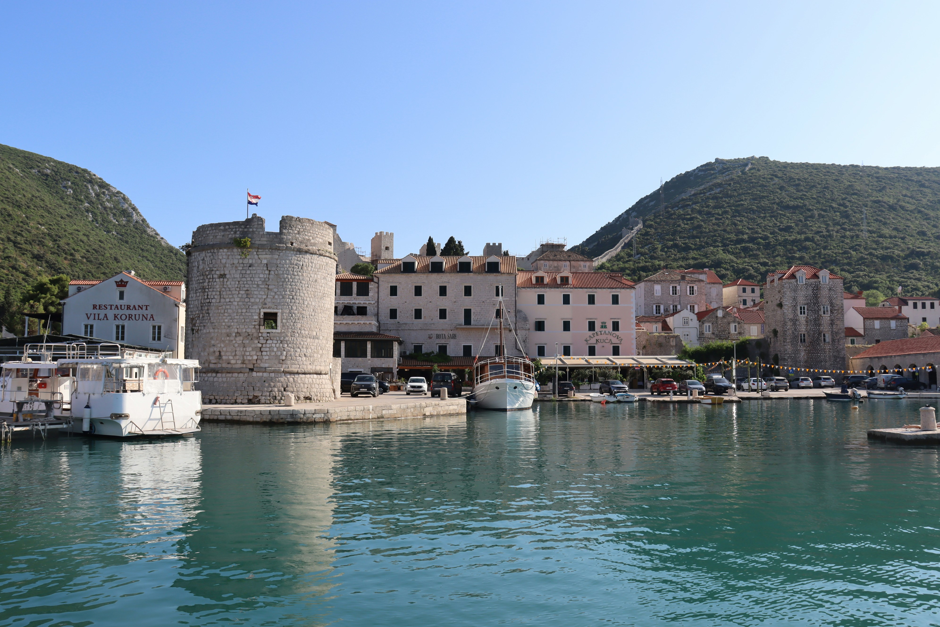 Coastal town with a round tower and boats