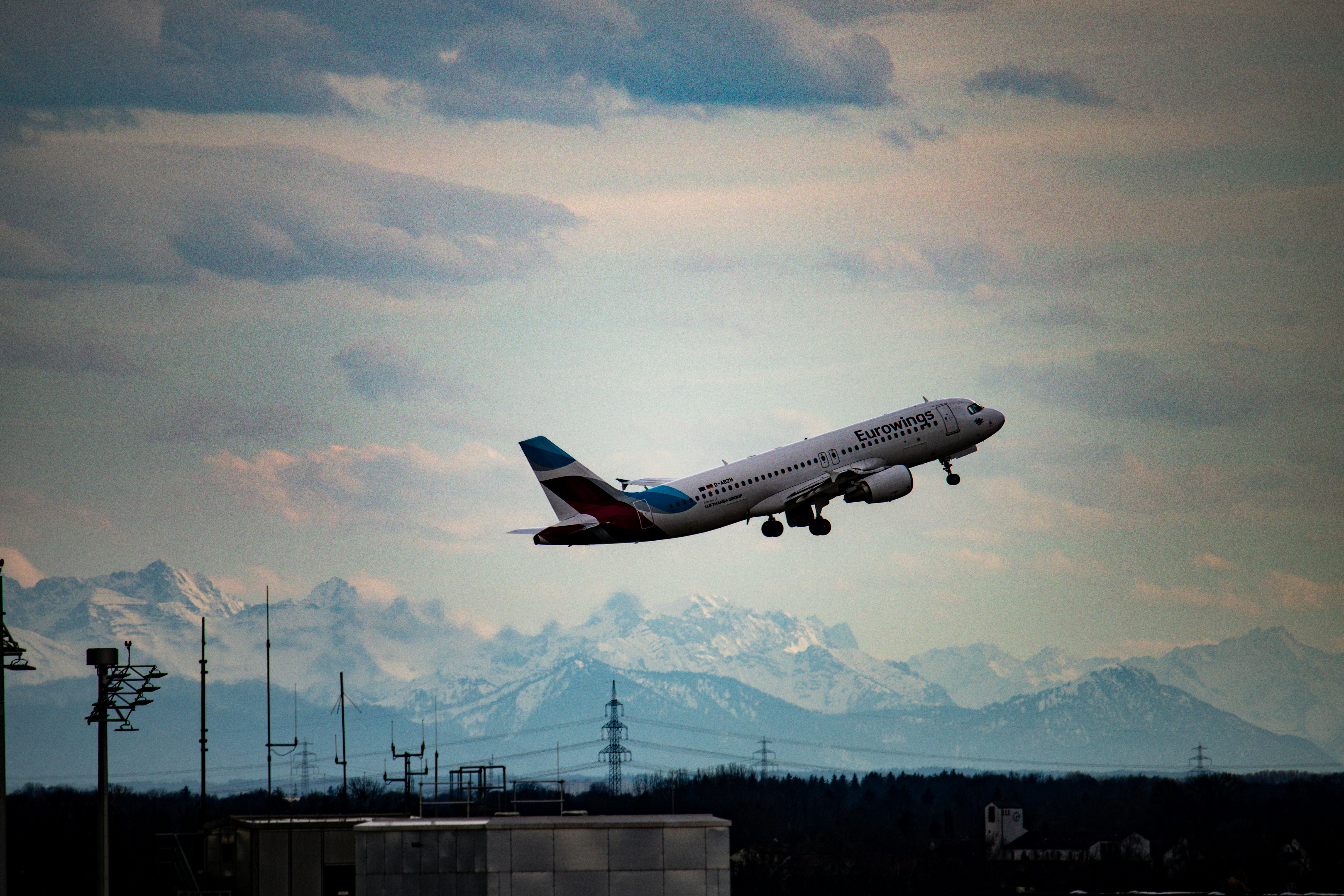Airplane taking off with mountains in background