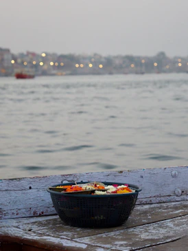Basket of flowers floating on water with city lights