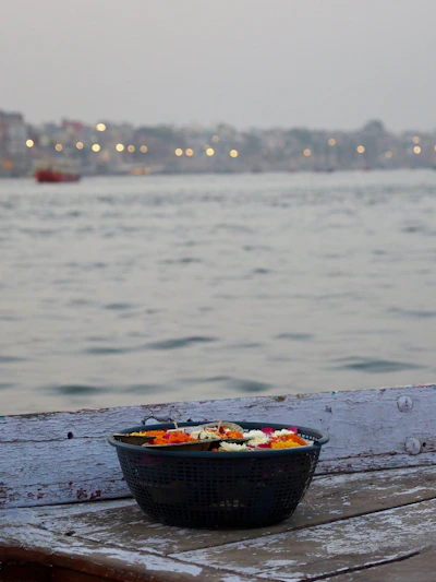 Basket of flowers floating on water with city lights