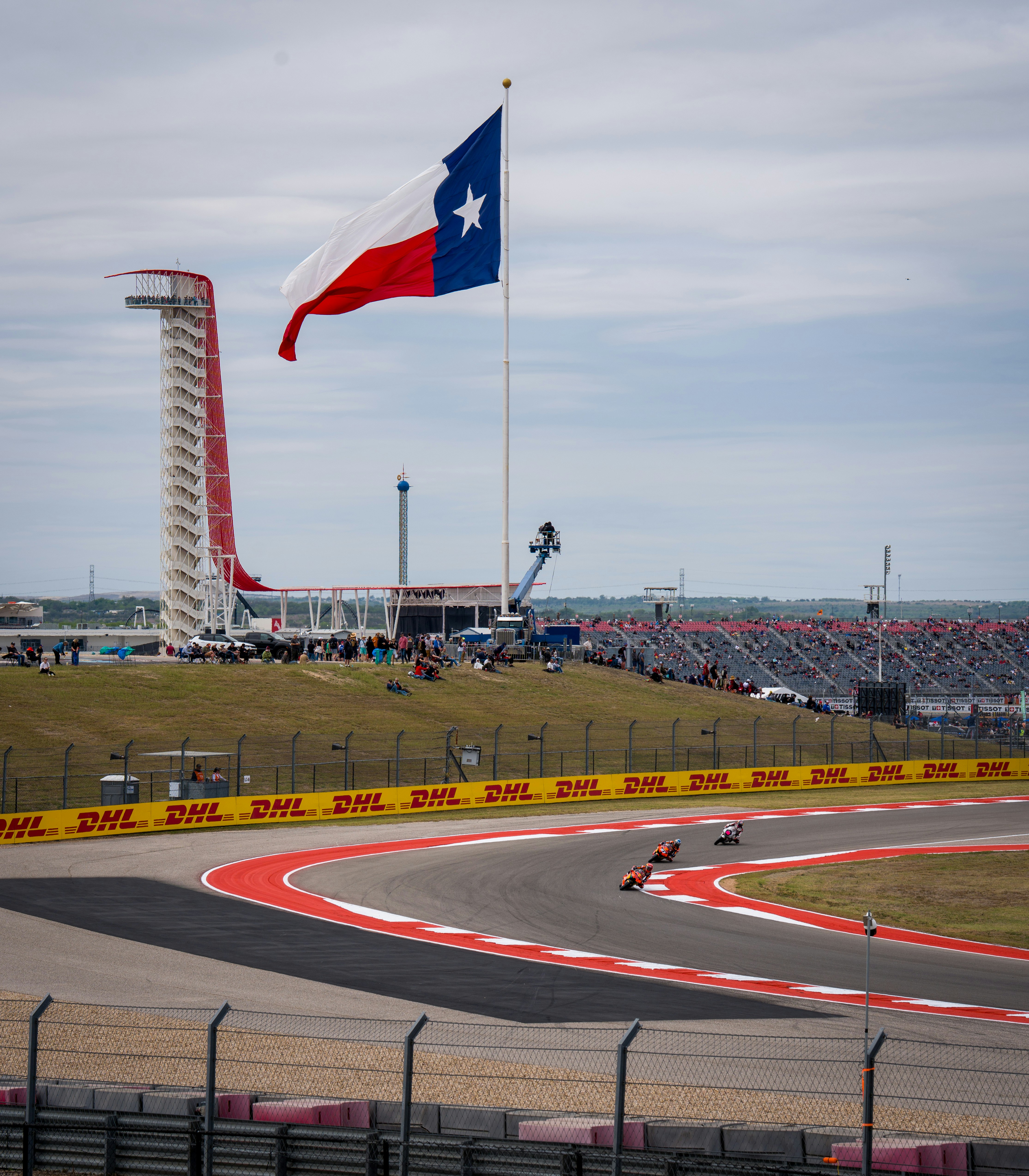 Le auto da corsa sfrecciano su un circuito con bandiera del Texas.