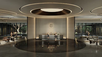 Modern hotel lobby with reception desk and seating areas.