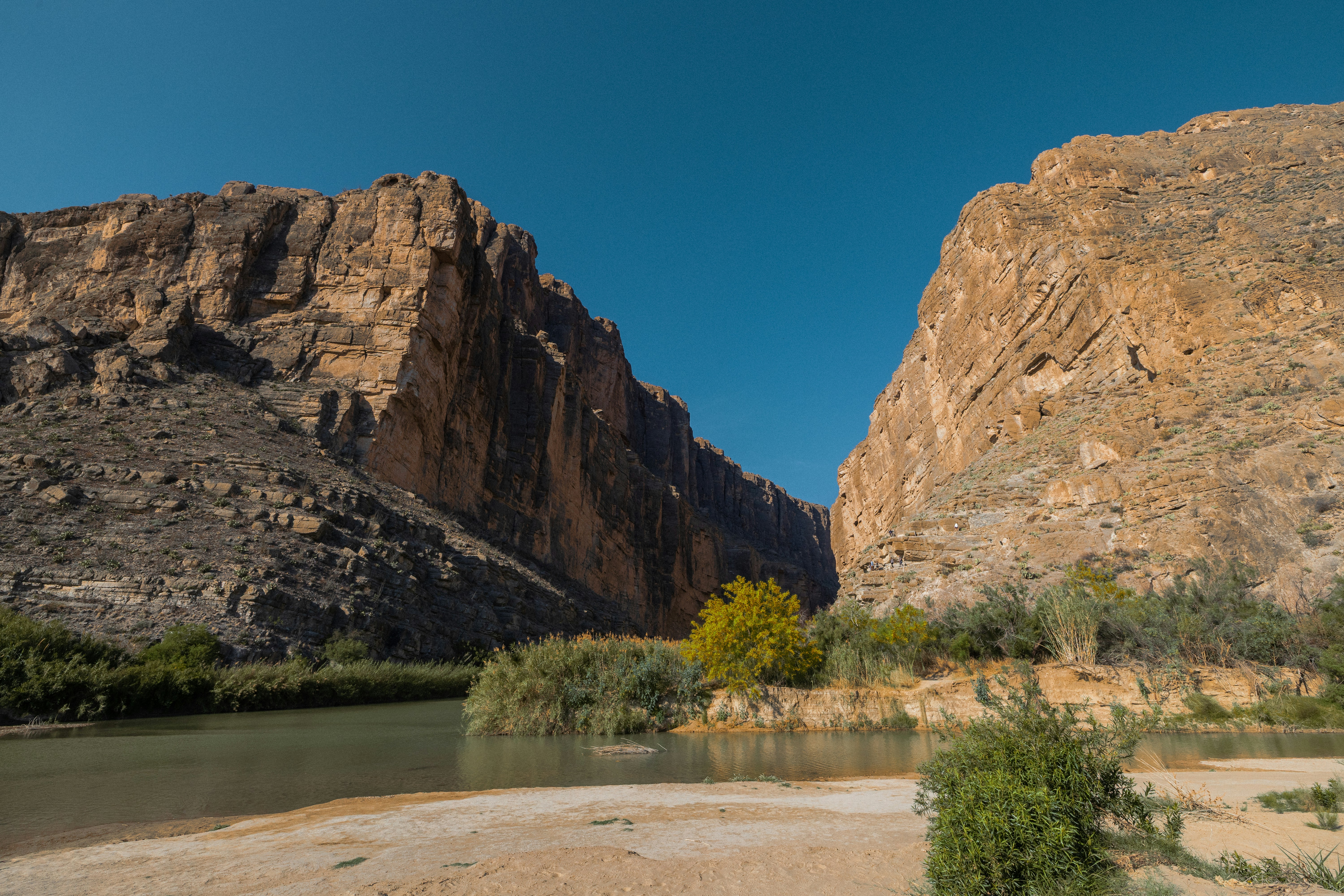 A river flows through a canyon with rocky cliffs.