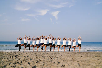 Group of people practicing yoga on the beach