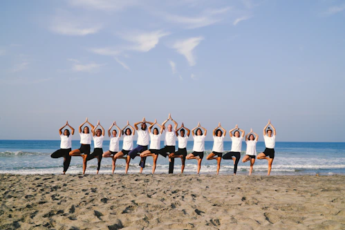 Group of people practicing yoga on the beach