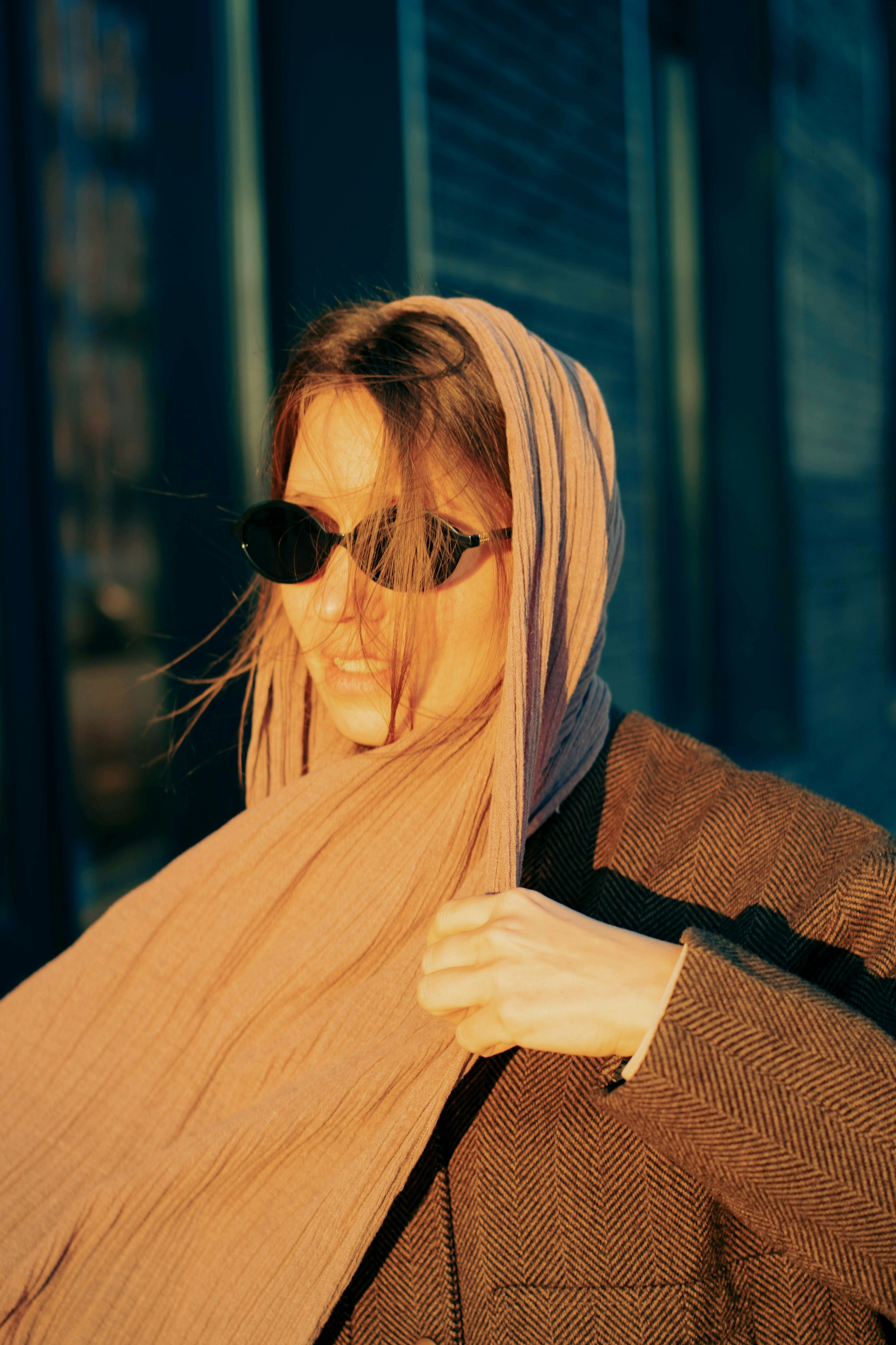 Woman wearing sunglasses and a headscarf outdoors