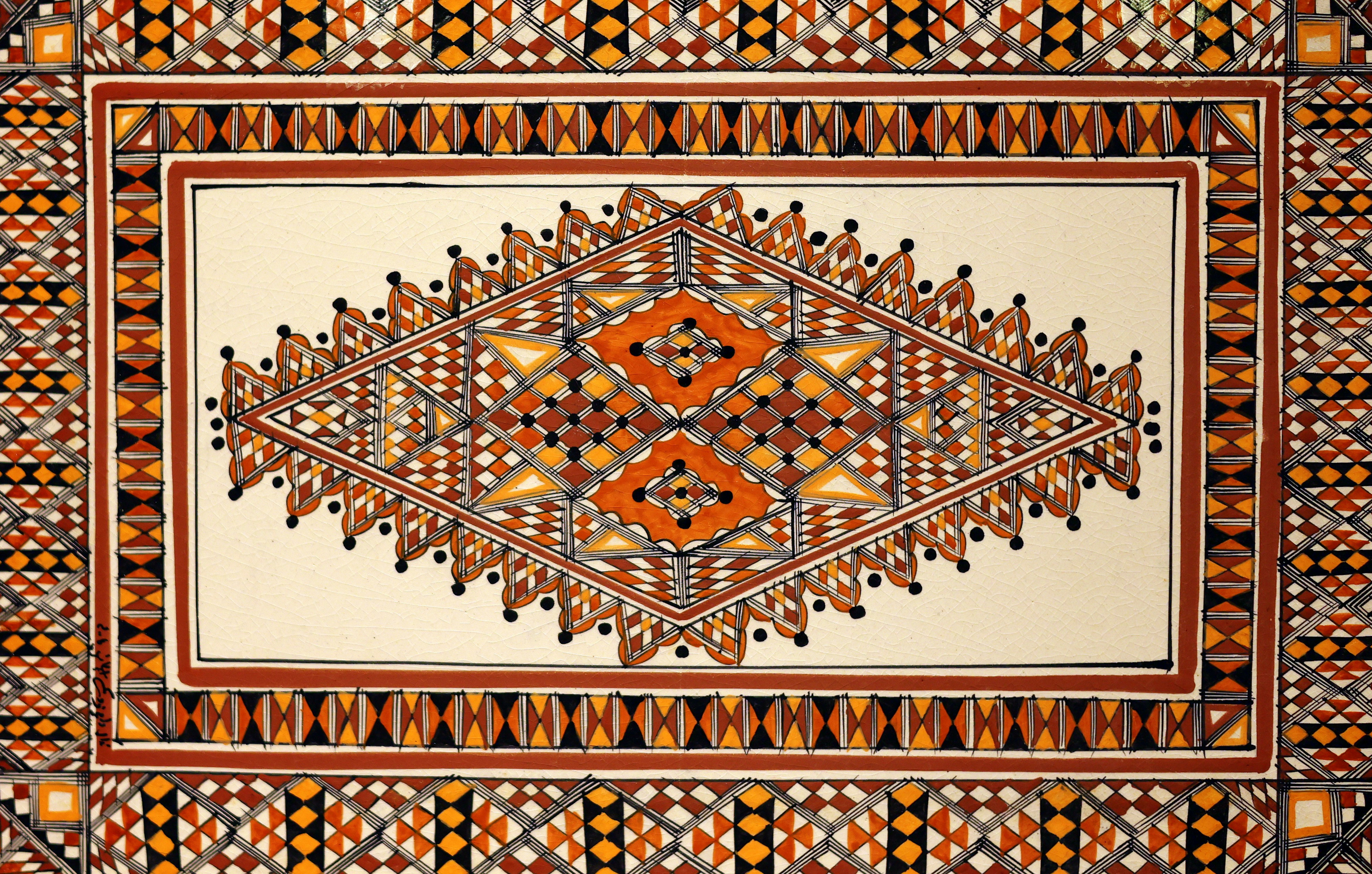 Intrincado patrón geométrico de mosaico con detalles naranjas y marrones