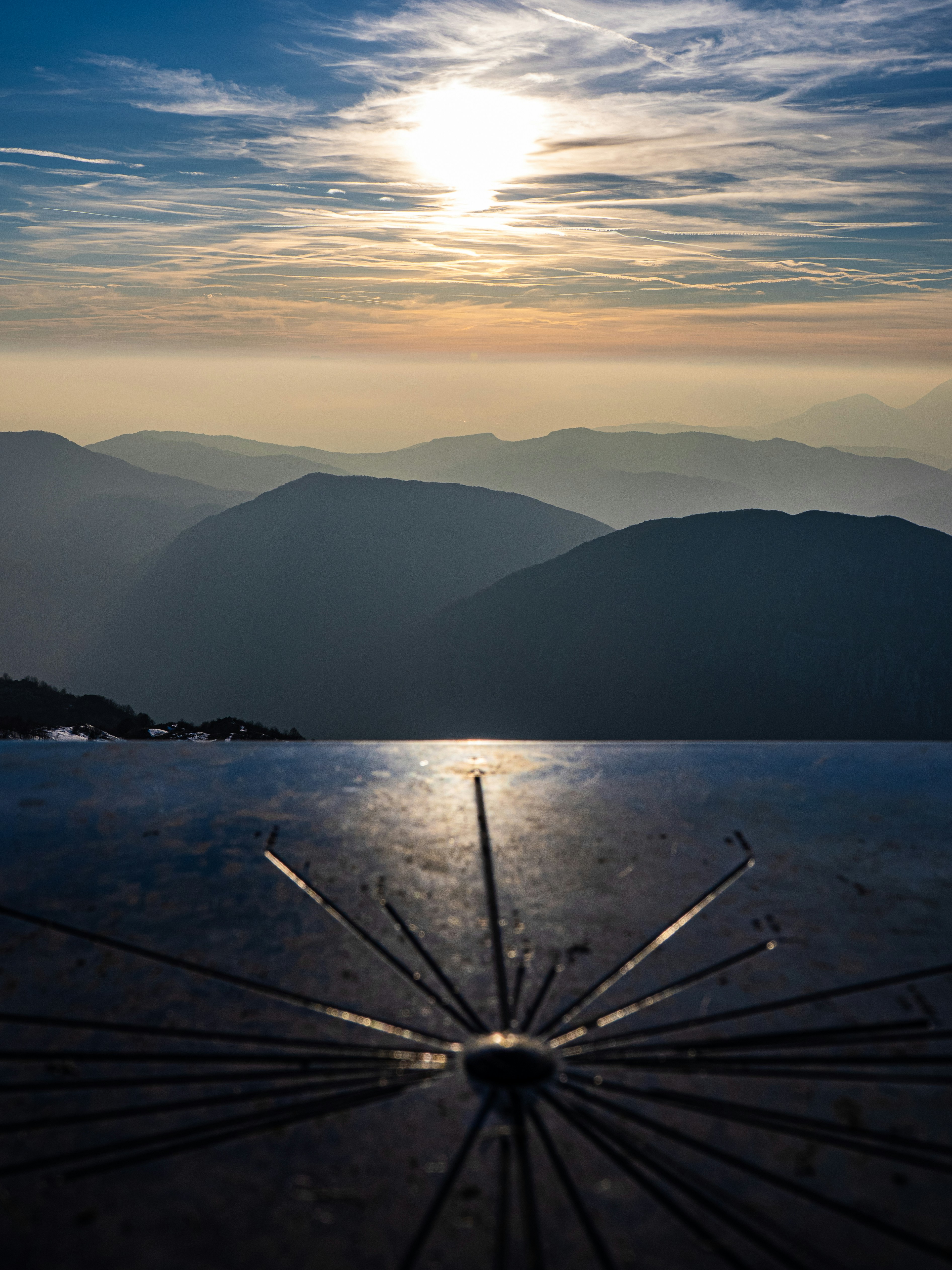 Sonnenlicht reflektiert sich auf Metallstrukturen mit Bergschichten.