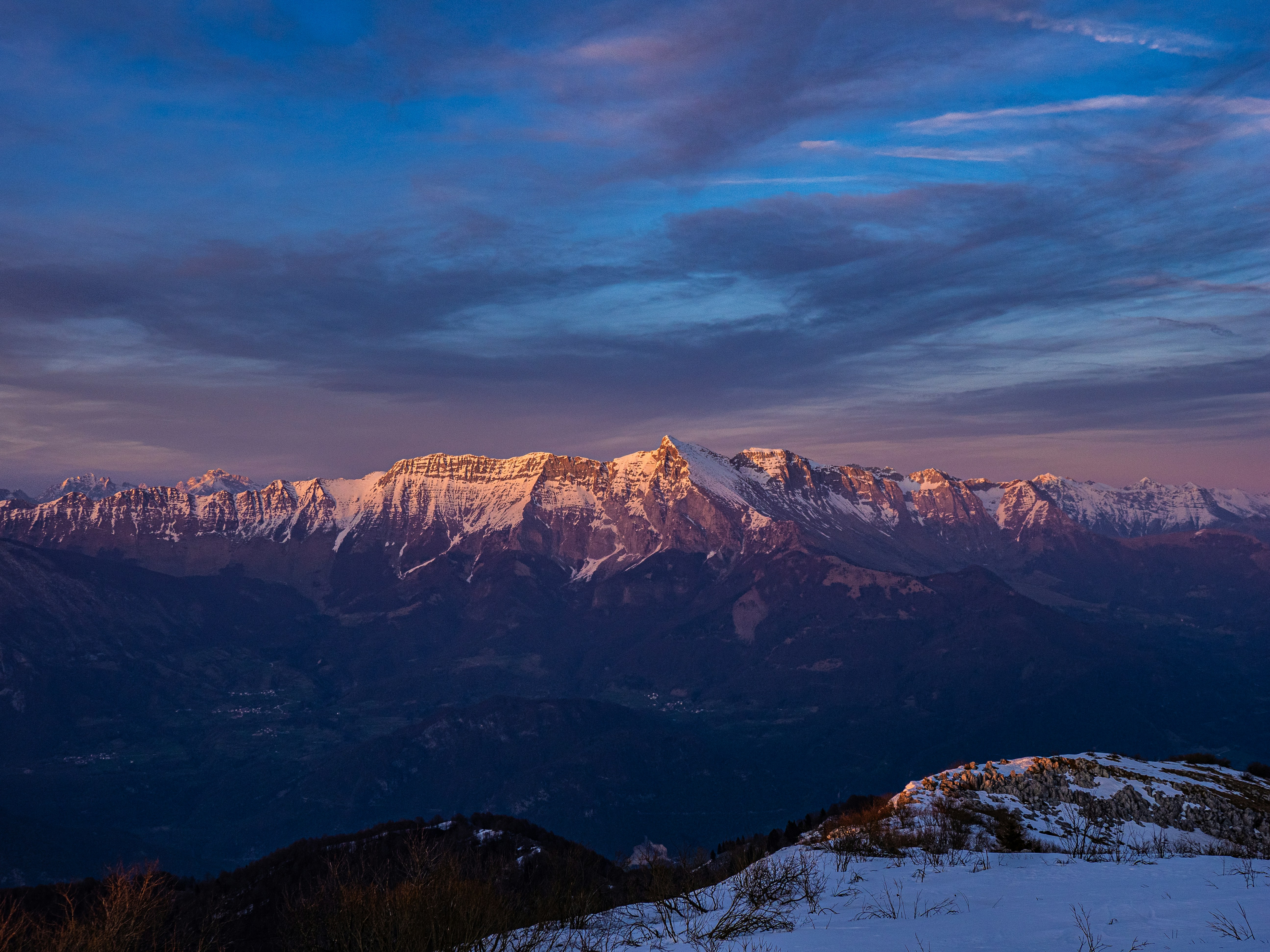 Schneebedeckte Berge, getaucht in rosa Sonnenaufgangslicht
