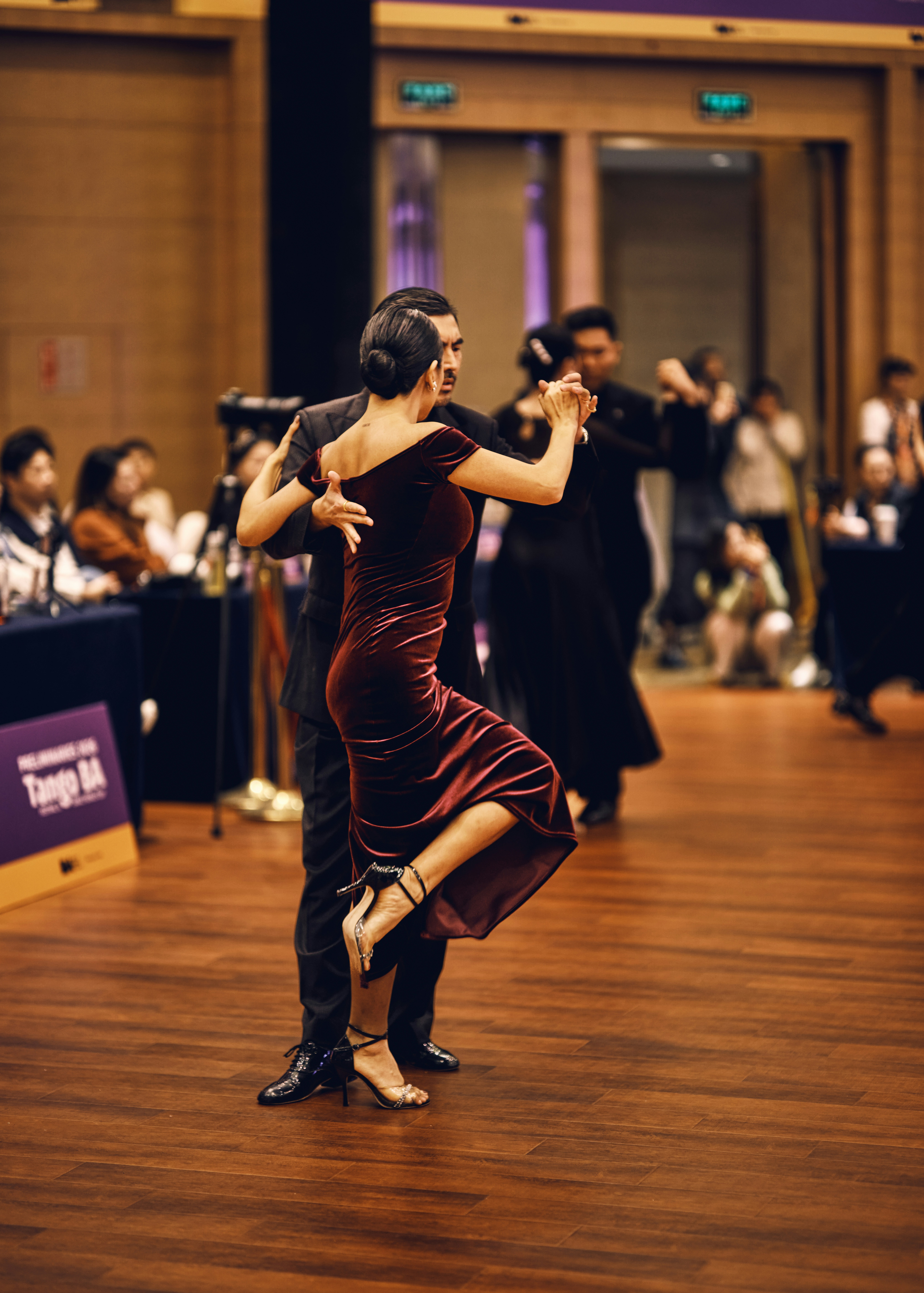 Un couple danse le tango sur un plancher en bois.