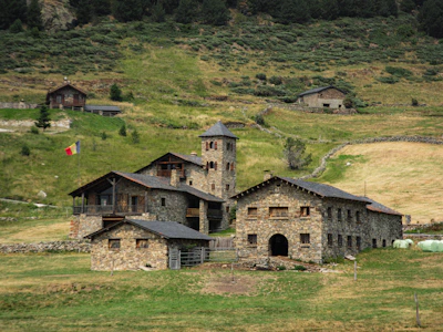 Stone buildings nestled on a grassy hillside