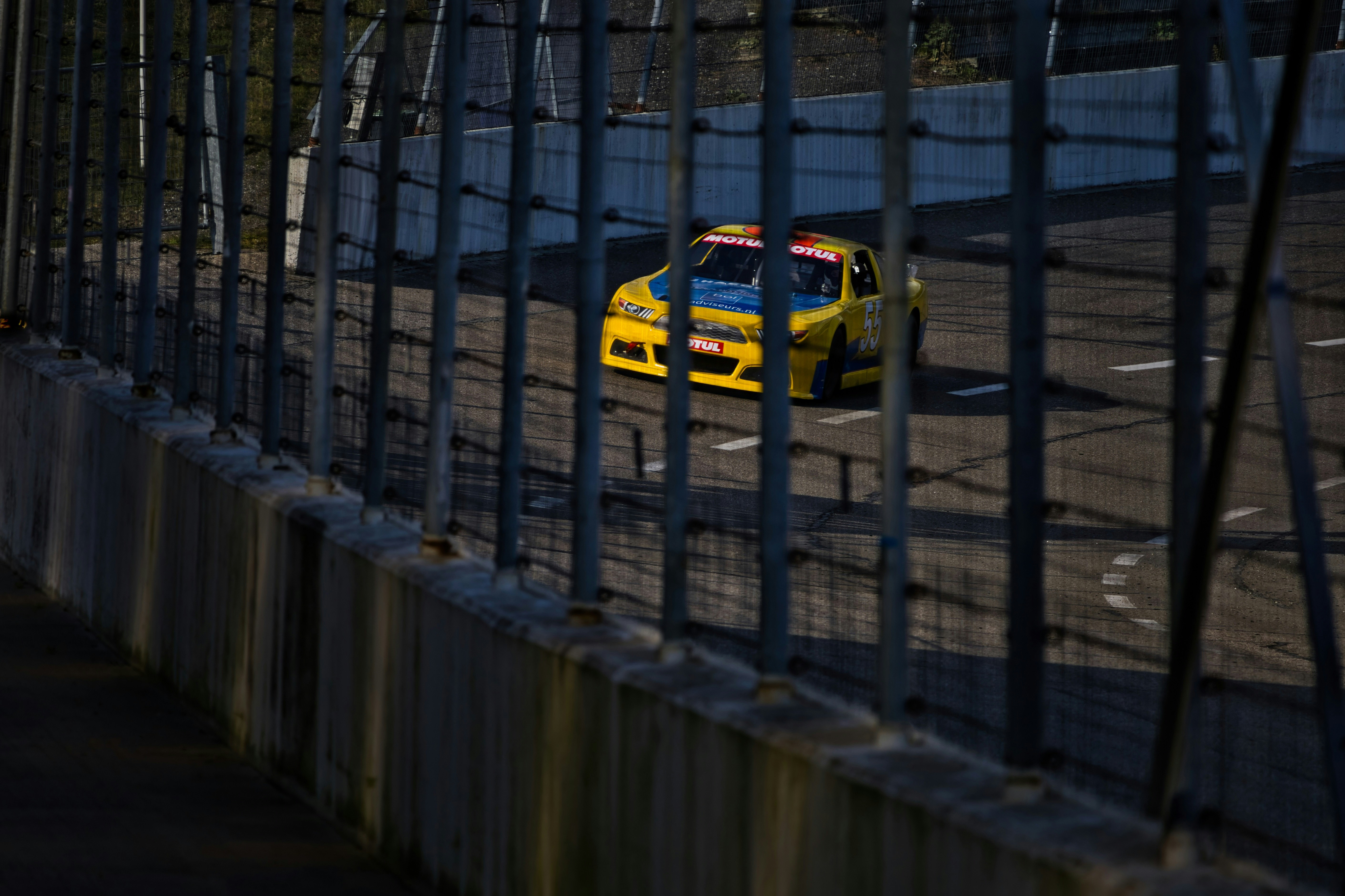 Yellow race car speeding on a track.