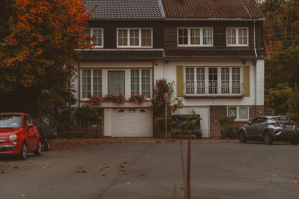 Suburban home surrounded by autumn trees — time for gutter cleaning