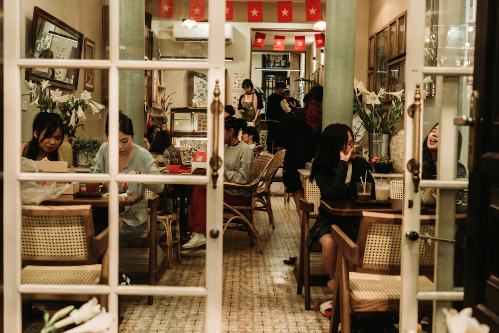 Beberapa orang berbincang santai di sebuah cafe modern yang hangat