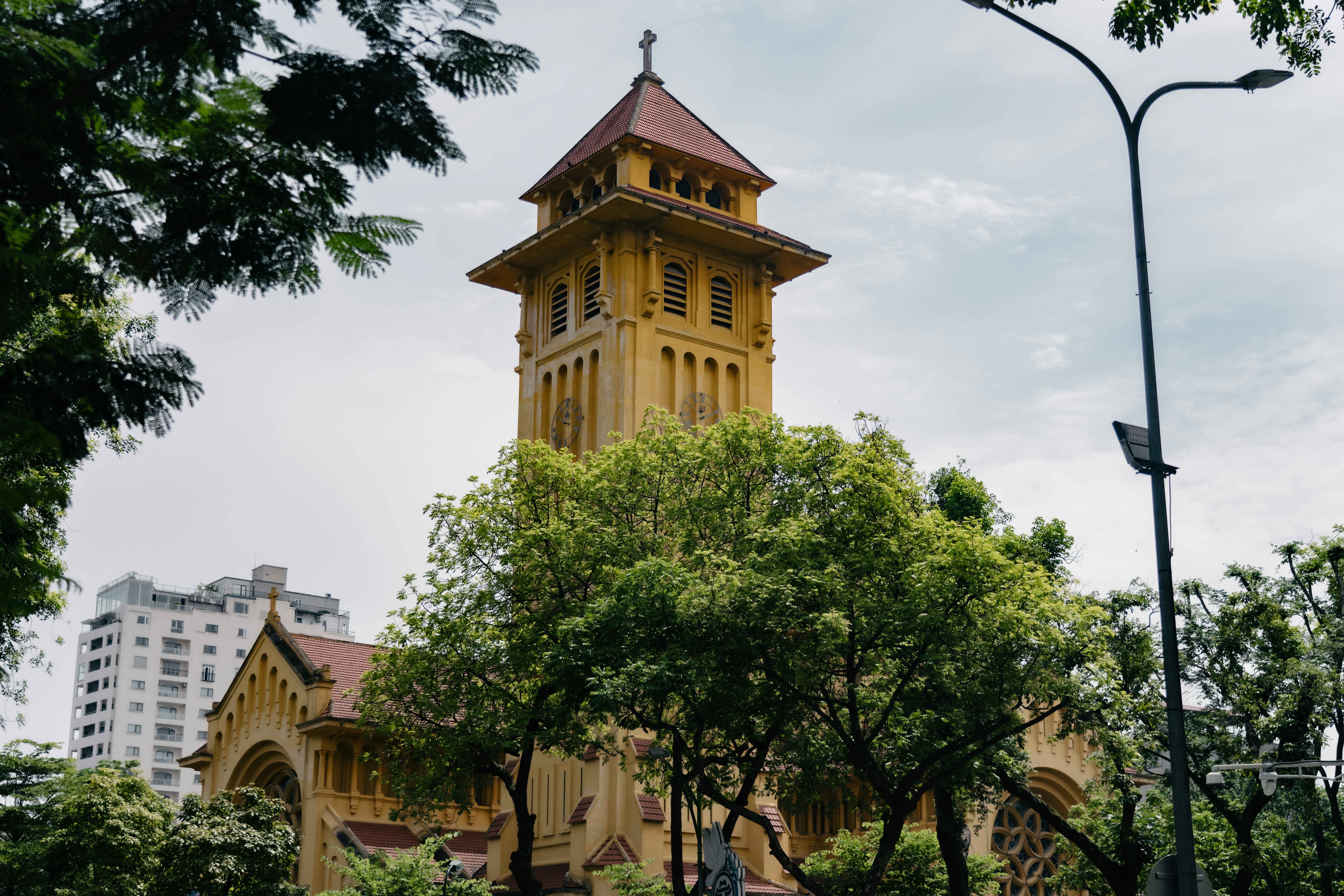 Yellow church with a tall tower and trees