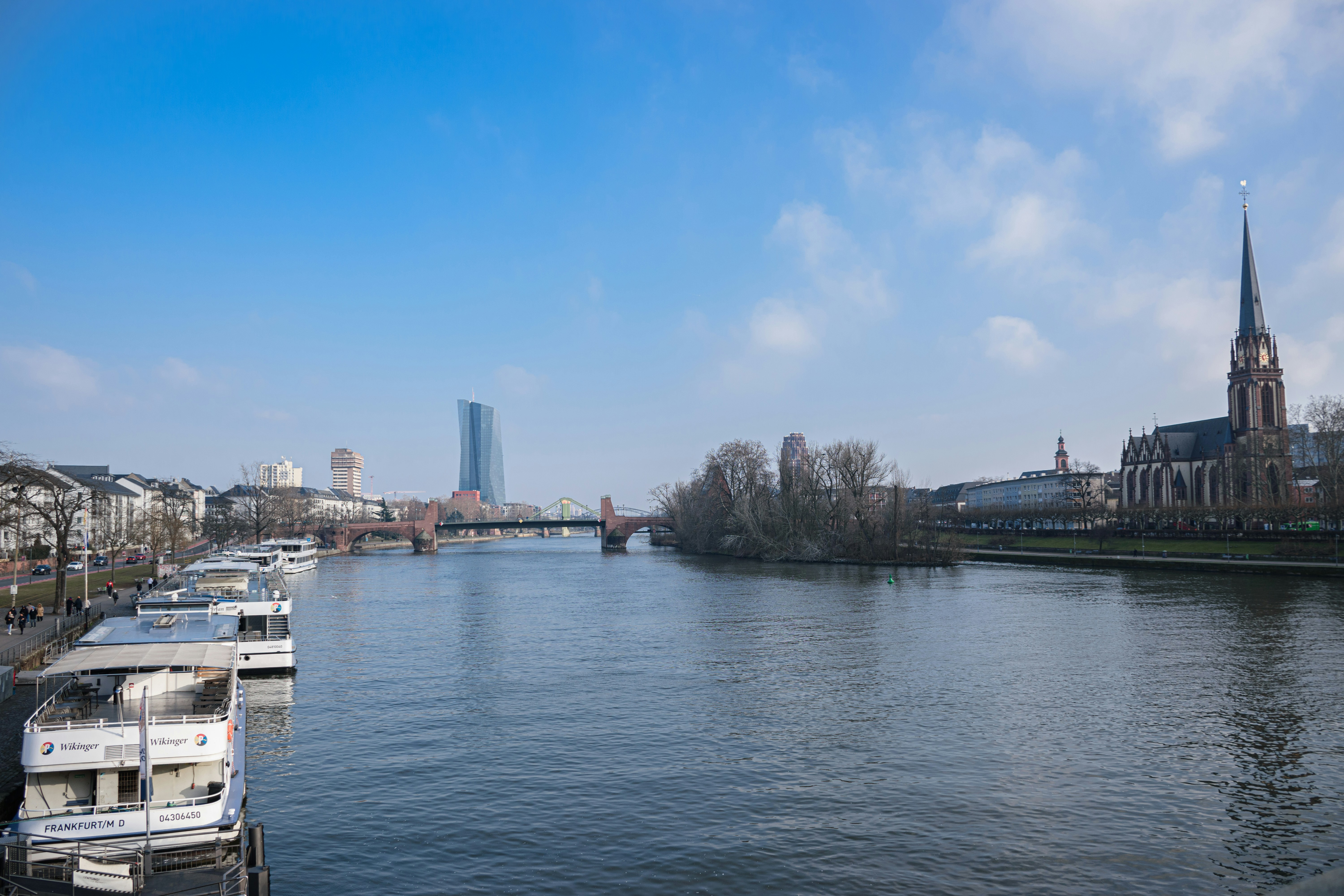 River with boats and city skyline under blue sky