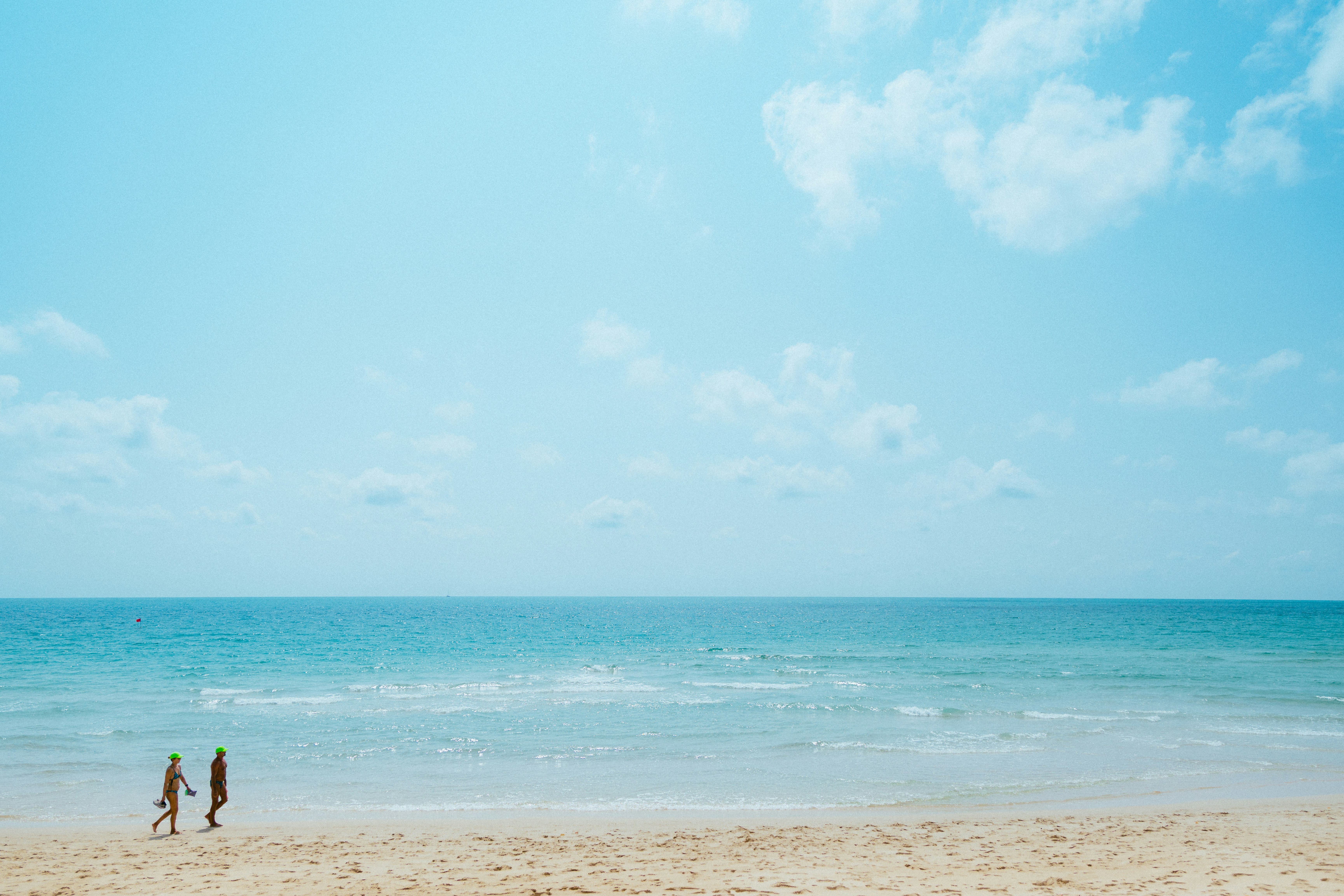 二人が海辺の砂浜を歩いている。