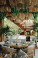 A tropical restaurant dining area with lush greenery.