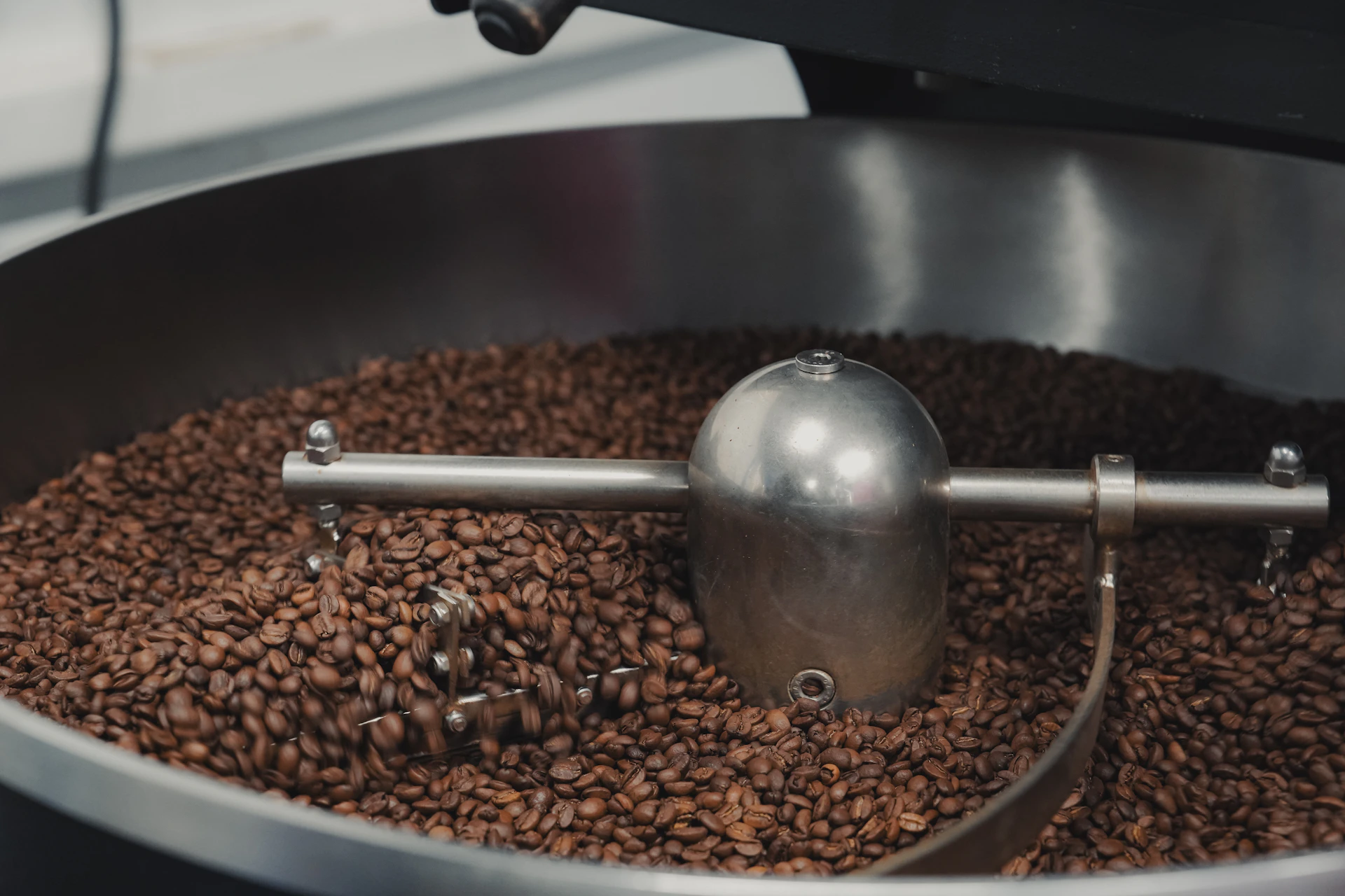 Coffee beans being roasted in a large industrial machine.