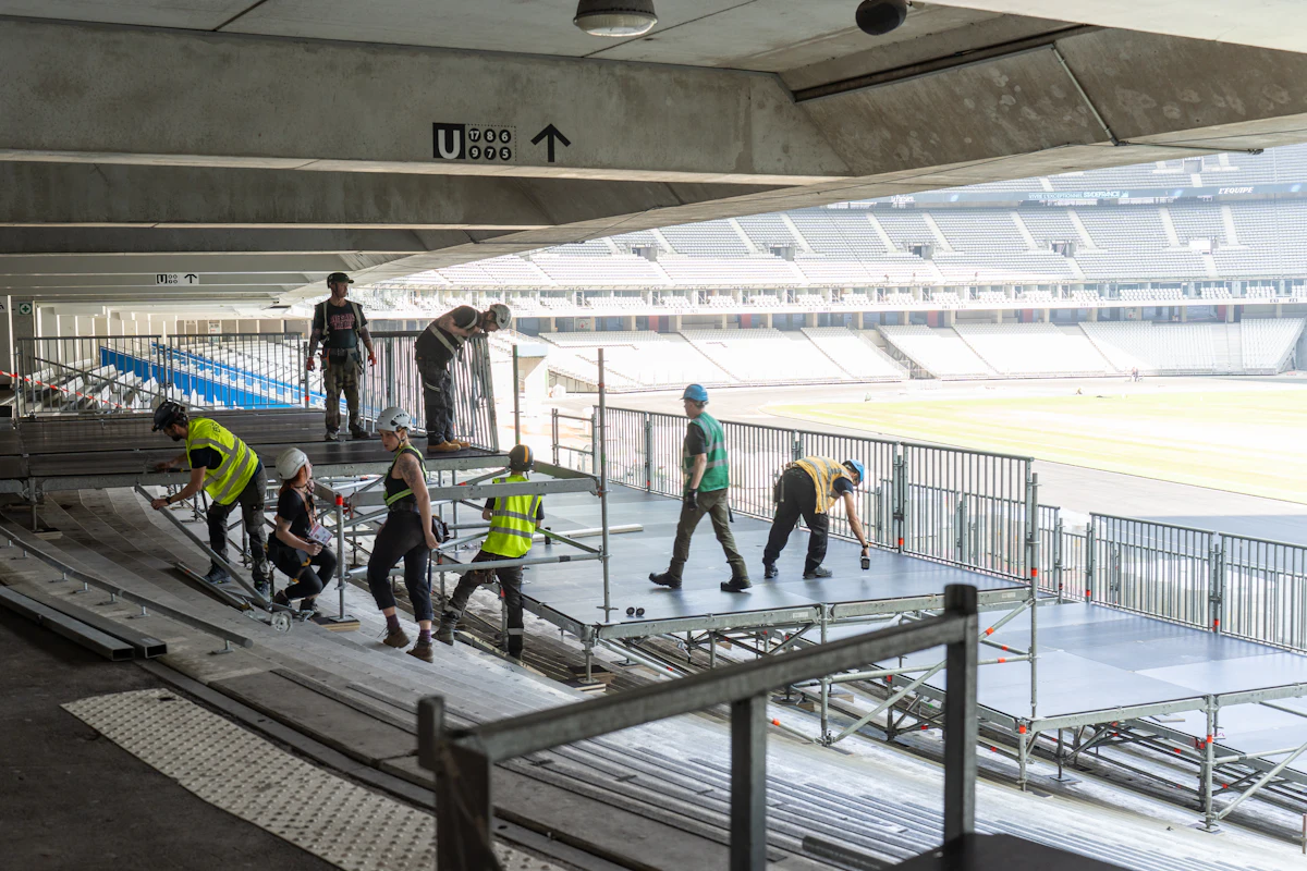 Equipa técnica a montar um palco num estádio