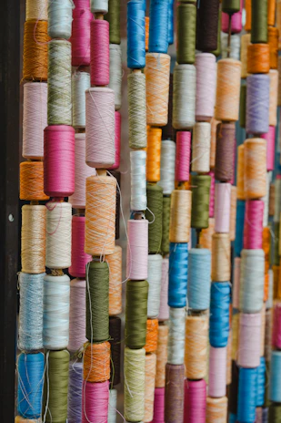 A colorful assortment of thread spools arranged vertically.