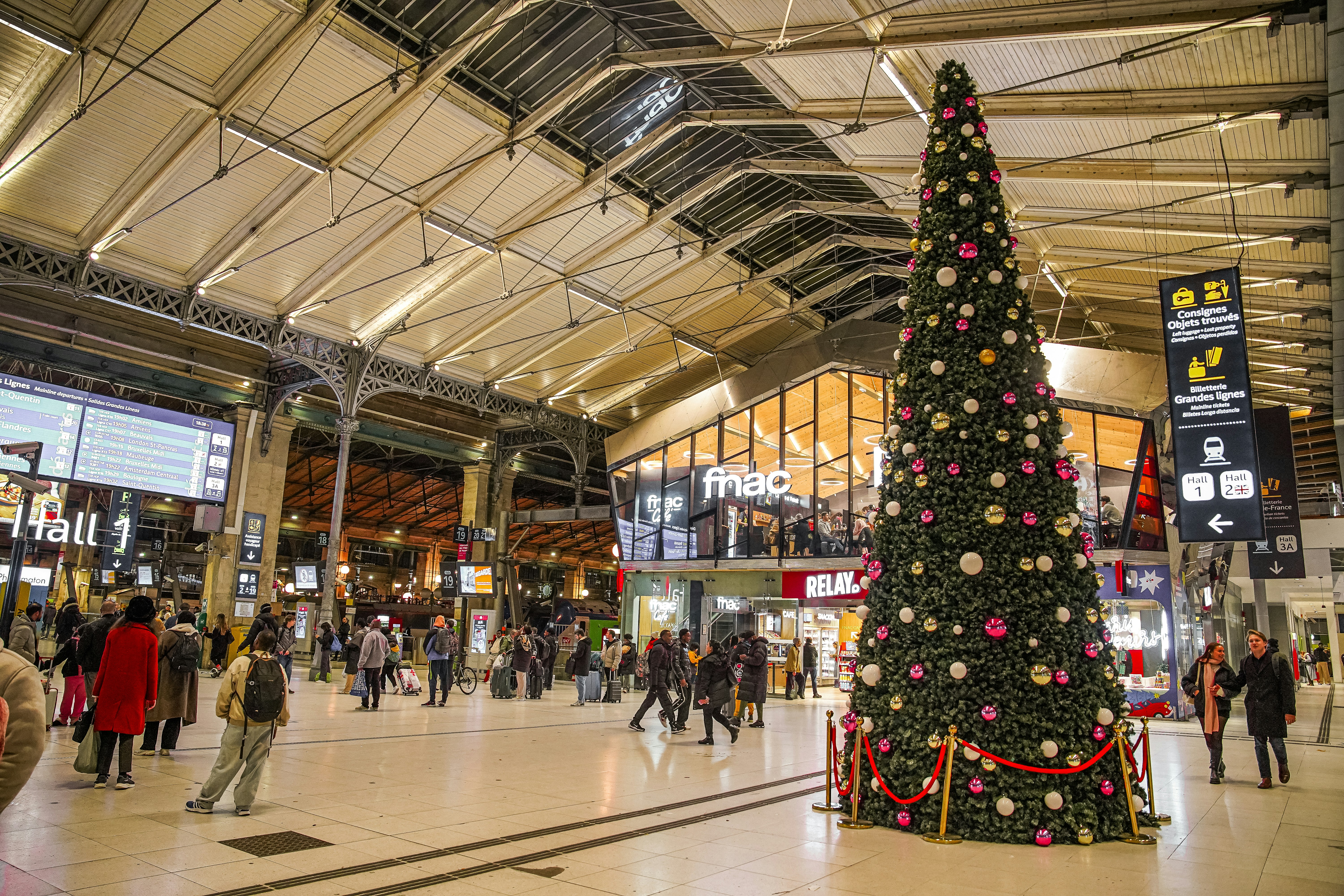 Großer Weihnachtsbaum in einem belebten Bahnhof